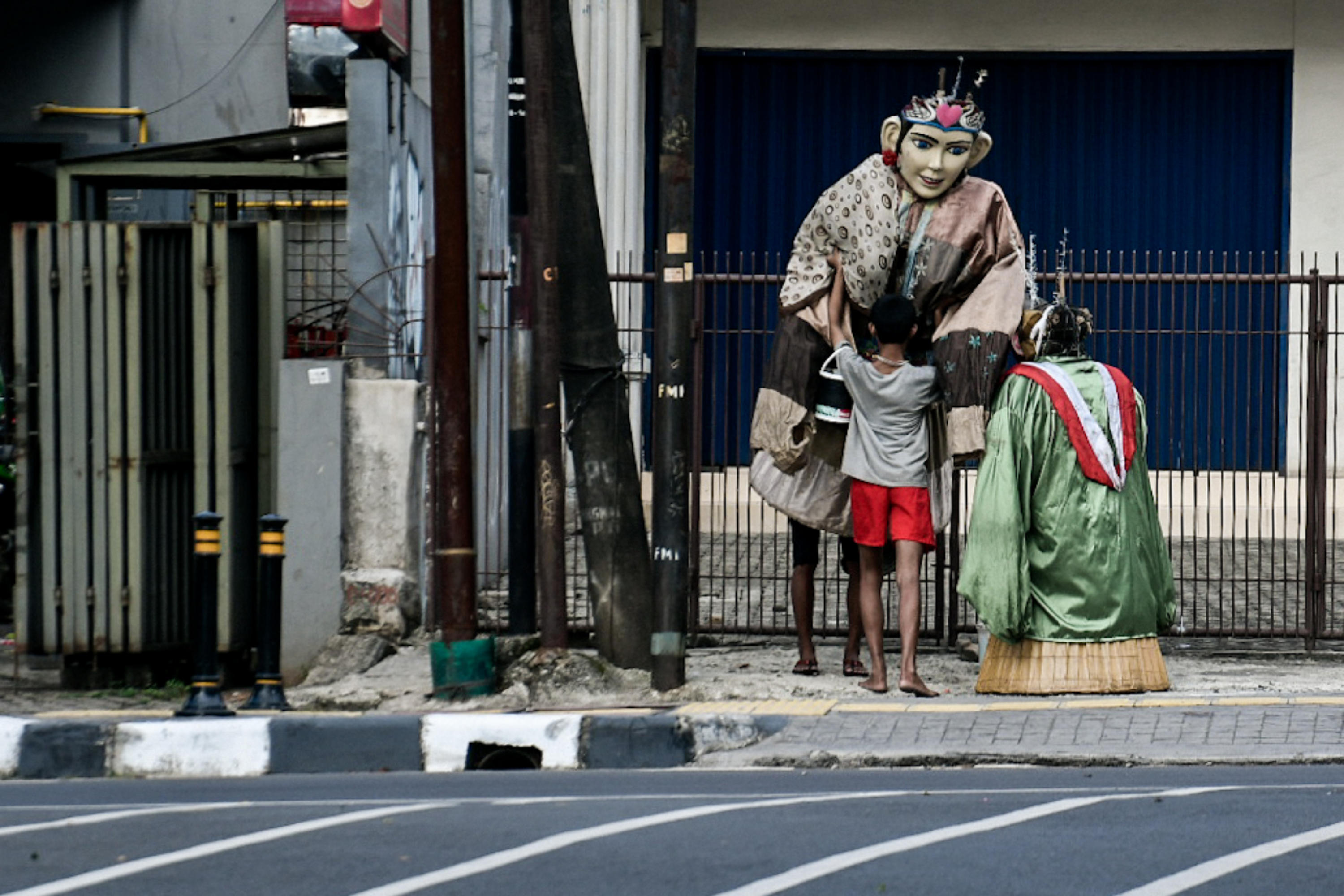 Pengamen ondel-ondel tengah bersiap untuk mengamen di kawasan Taman Puring, Jakarta.