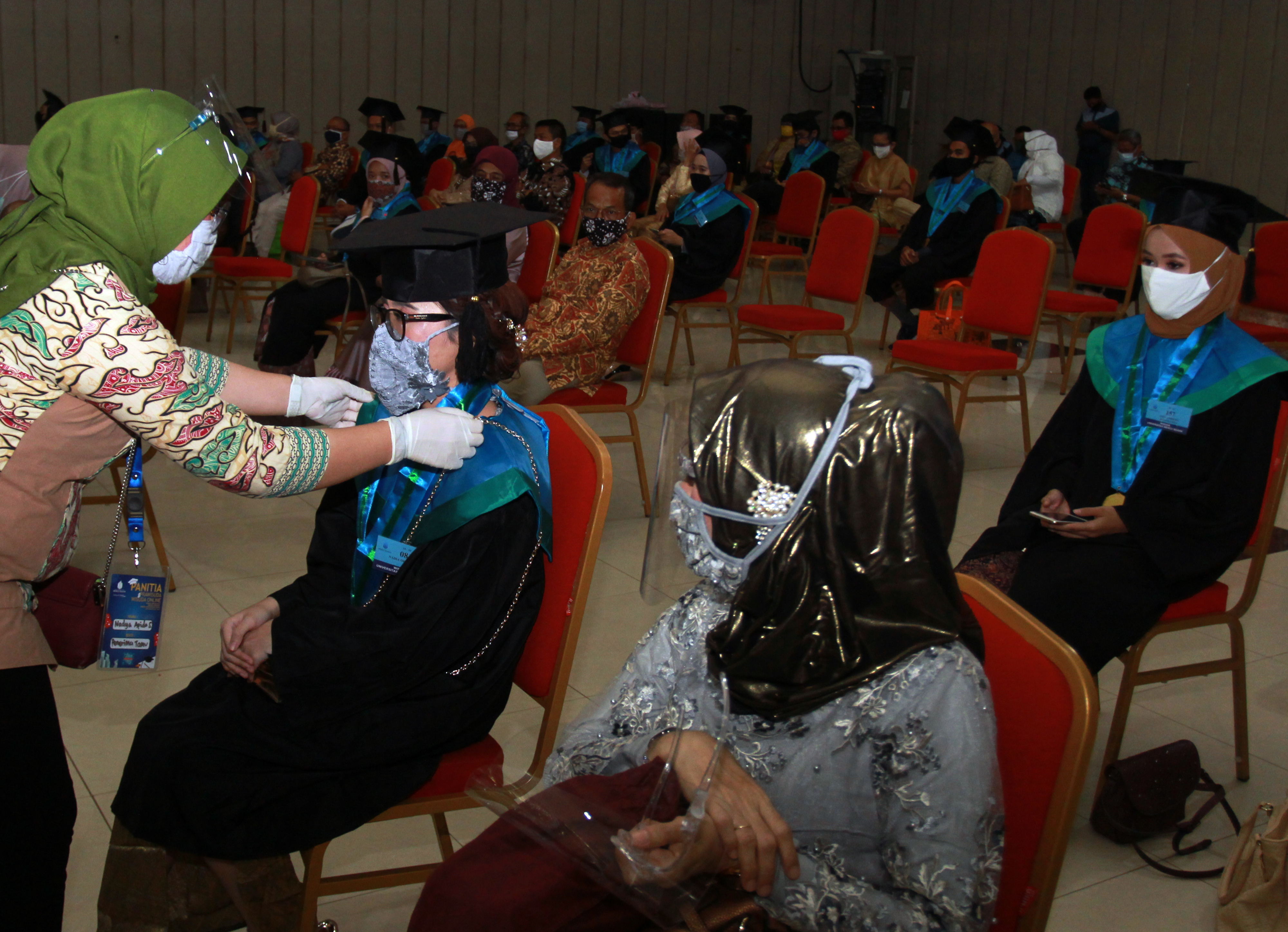  PRAWISUDA TATAP MUKA: Petugas merapikan baju toga wisudawan sebelum acara prawisuda di Universitas Mercu Buana, Joglo, Jakarta Barat, Senin