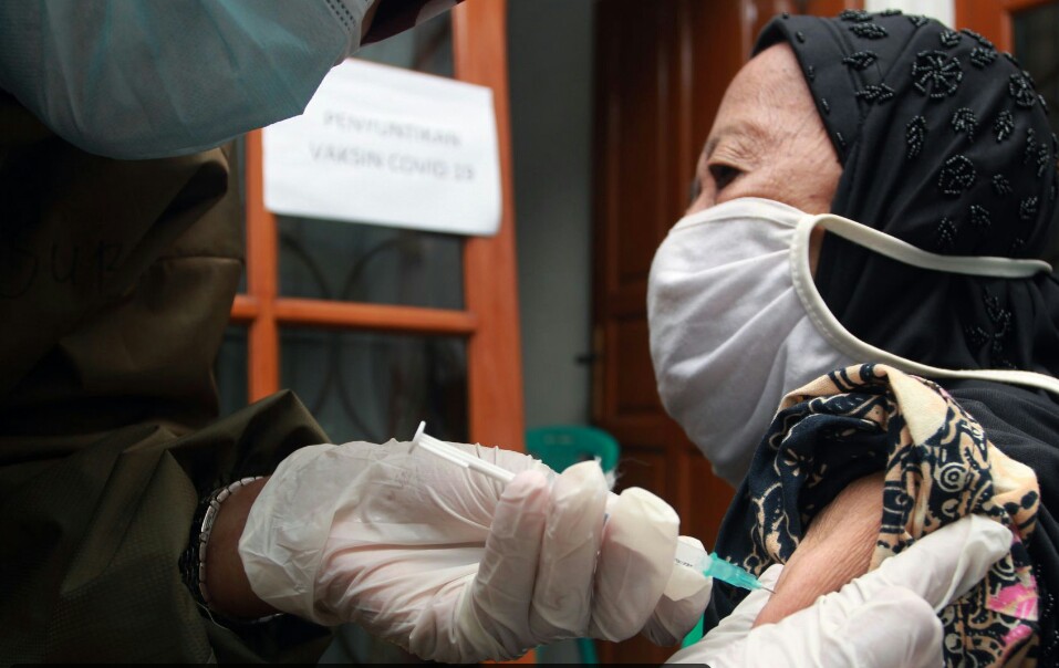 Vaksinator menyuntikkan vaksin covid-19 kepada lansia di Jakarta Timur.