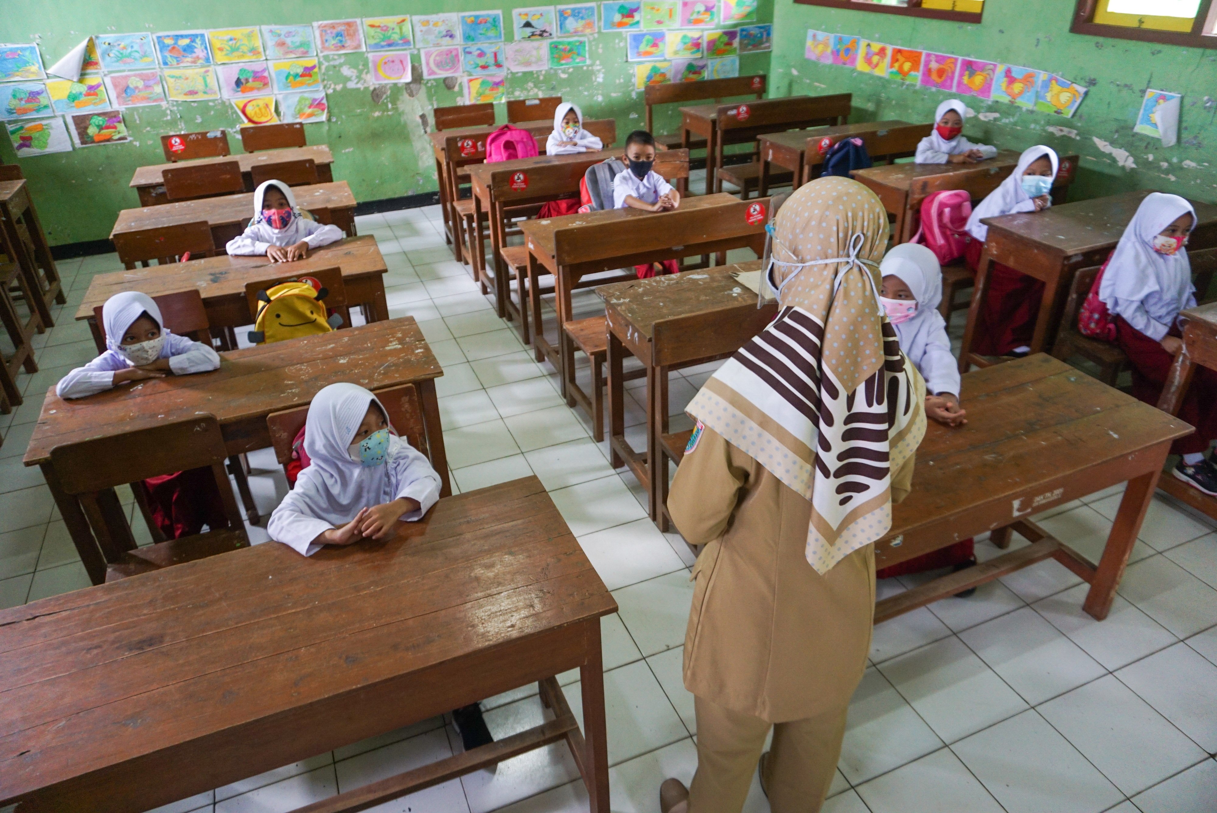  Guru menerangkan pelajaran kepada siswa saat mengikuti Pembelajaran Tatap Muka (PTM) di SD N Simbangdesa 1, Tulis, Kabupaten Batang, Jateng