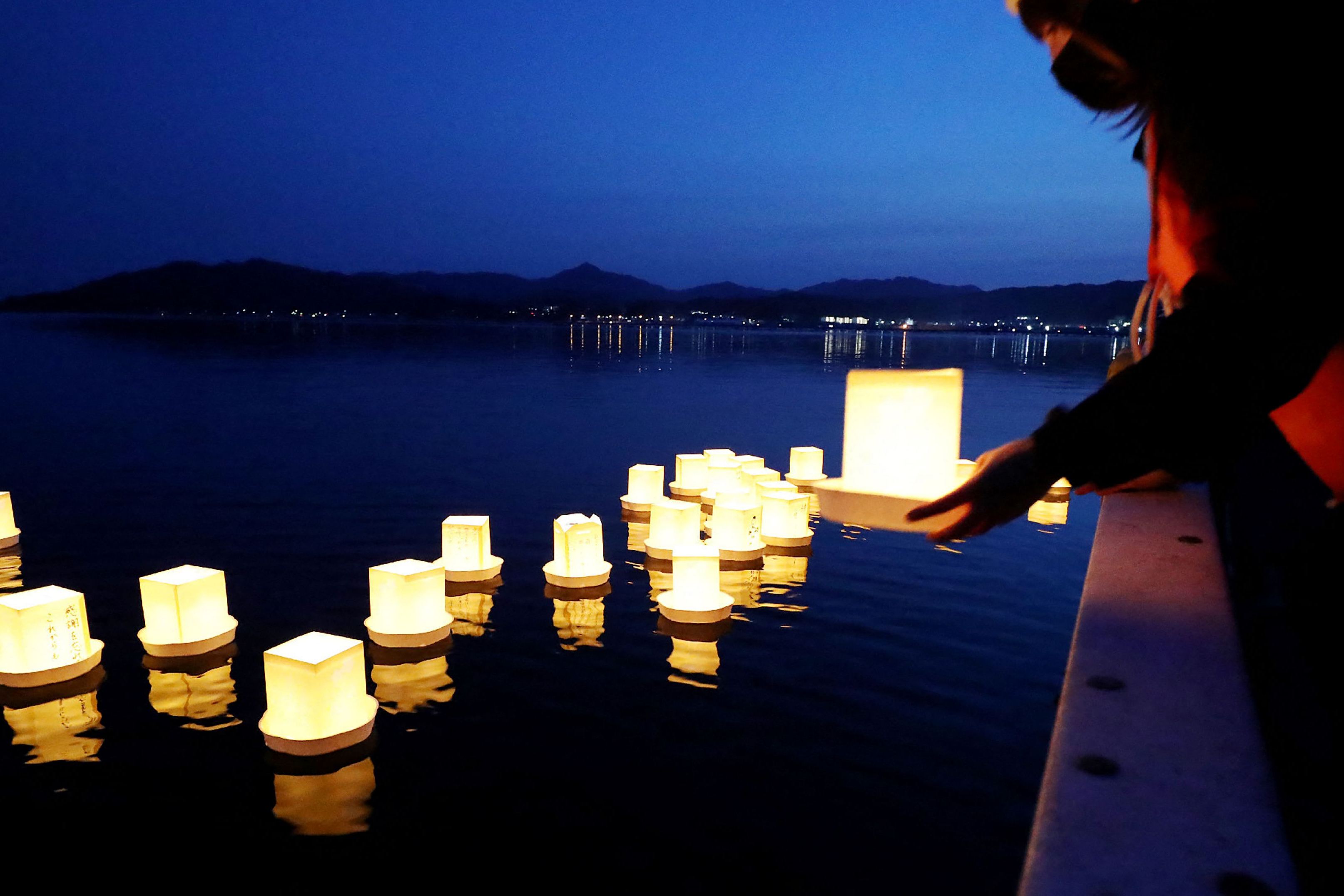 Seorang wanita melepaskan lentera untuk korban gempa dan tsunami di Yamada pada peringatan 10 tahun gempa berkekuatan 9,0 di Jepang.