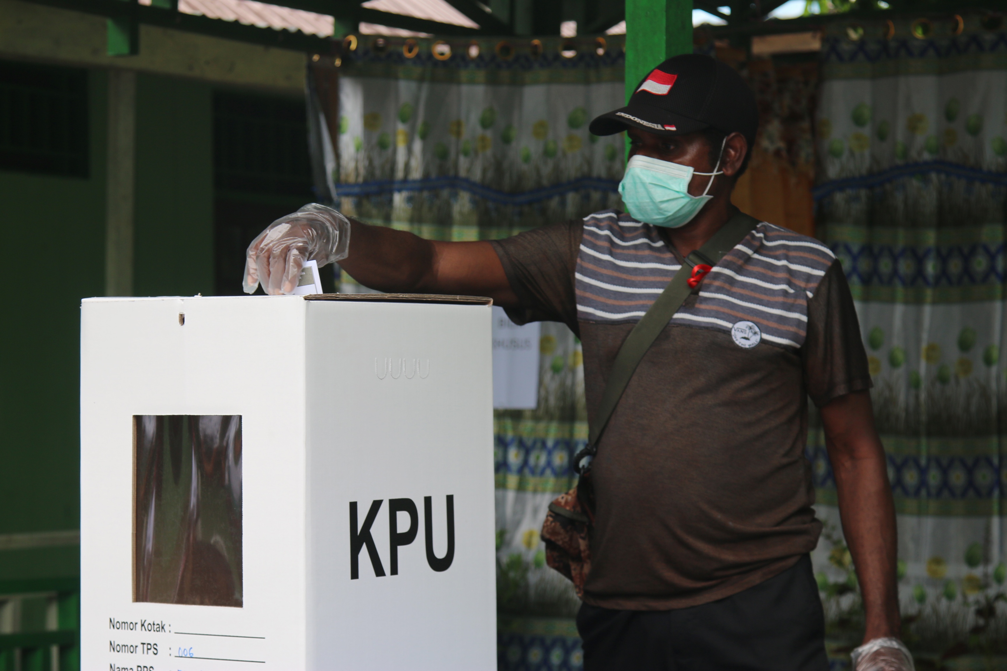 Warga Kabupaten Asmat melakukan pencoblosan dengan menerapkan protokol kesehatan di TPS 006 Distrik Agats, Kabupaten Asmat, Papua.