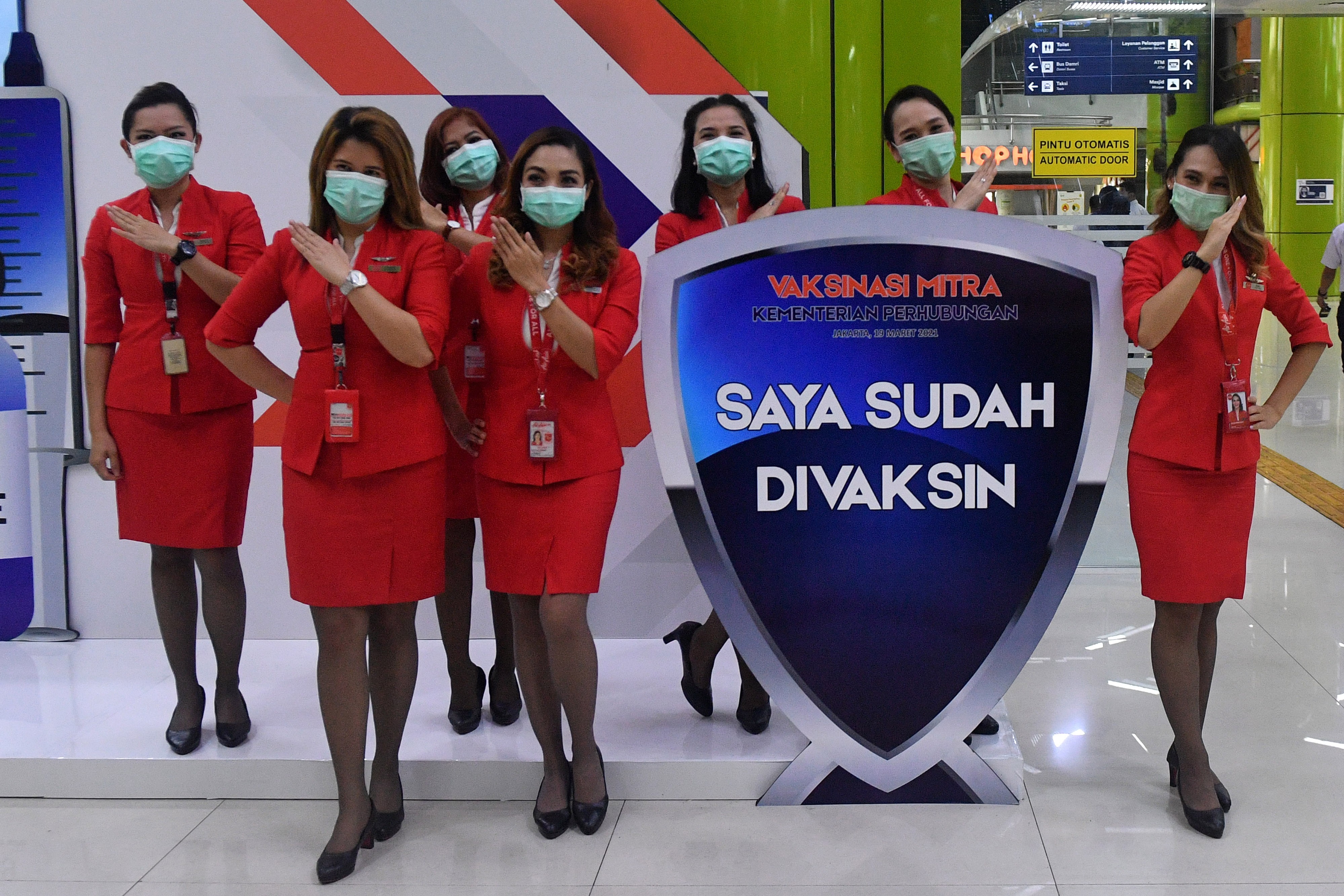 Sejumlah pramugari Air Asia berpose seusai mendapatkan vaksinasi dosis pertama di Stasiun Gambir, Jakarta, Jumat (19/3).