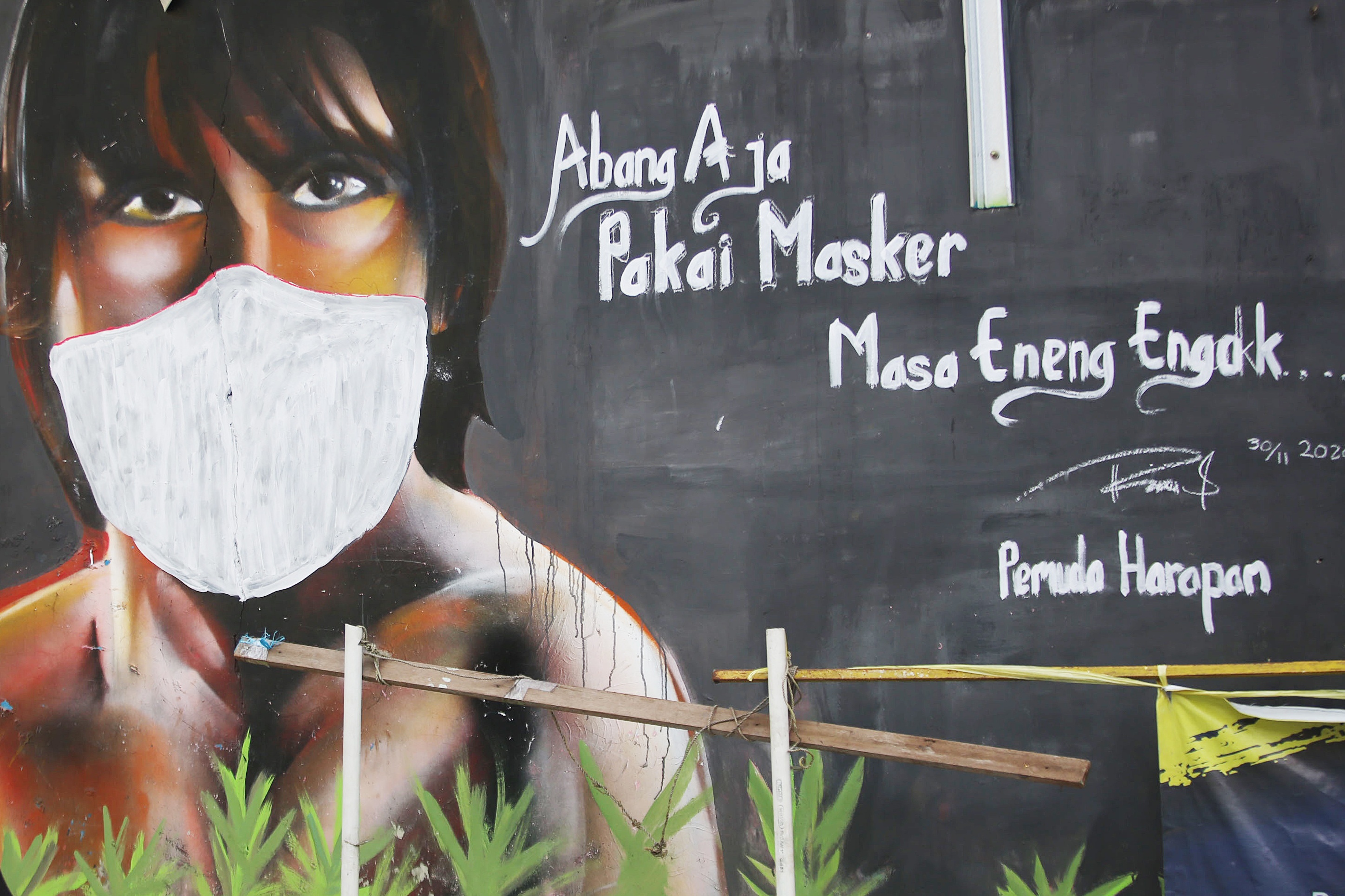 Mural berisi imbauan menggunakan masker di Jakarta, beberapa waktu lalu.