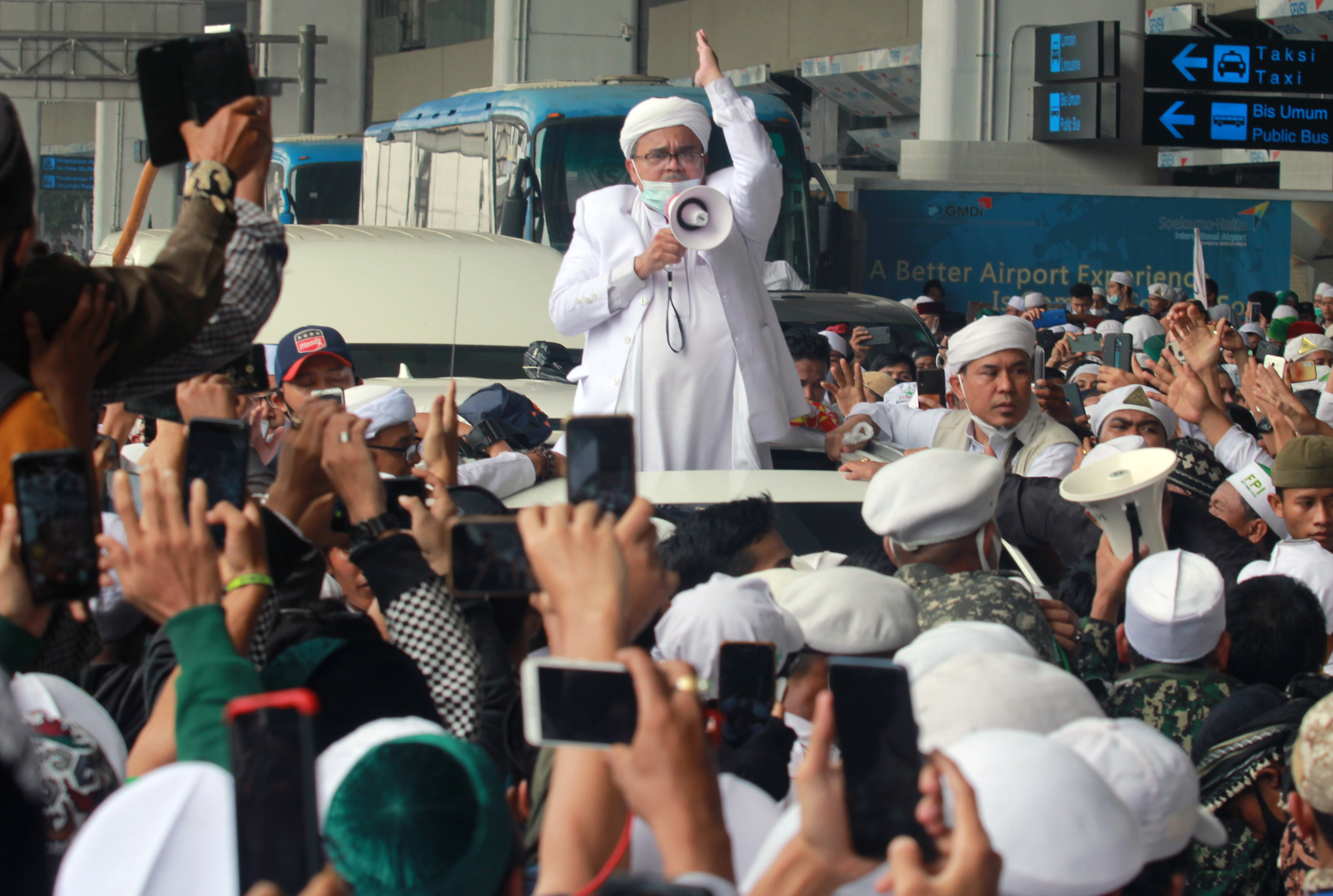 Rizieq Shihab (HRS) menyapa massa yang menjemputnya di Terminal 3 Bandara Soekarno Hatta, Tangerang, Banten, Selasa (10/11/2020). 
