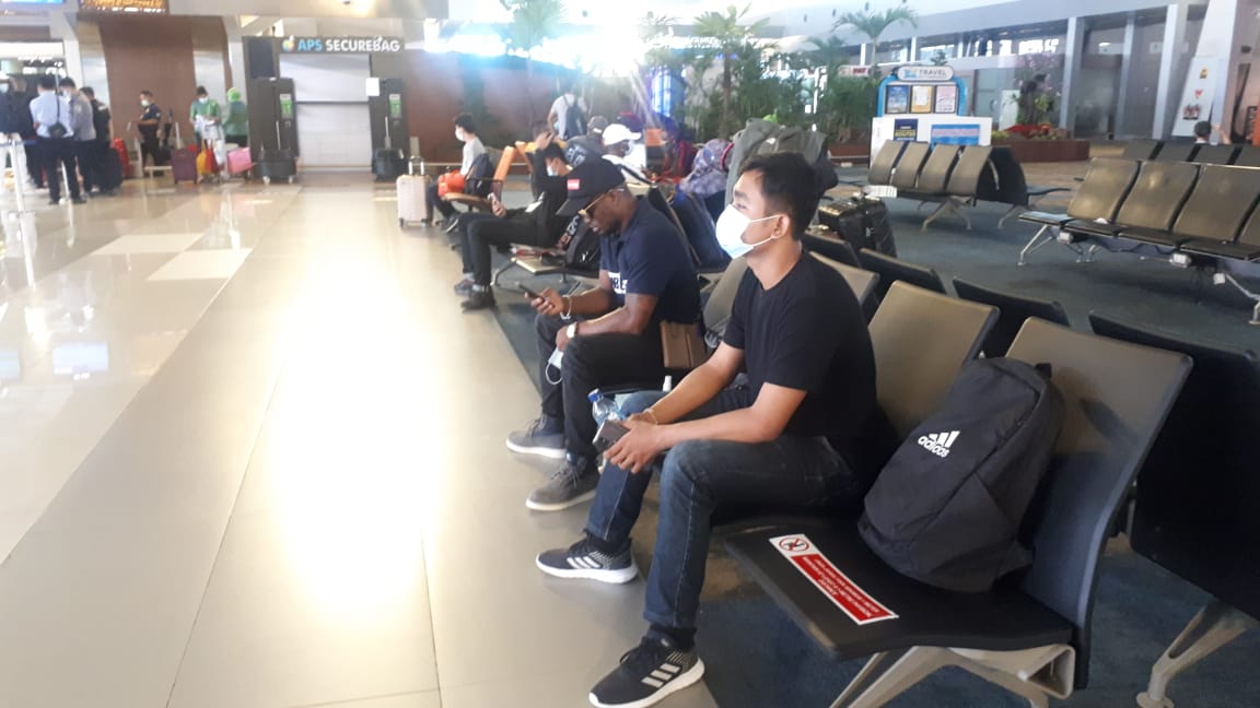  Petugas dari Kantor Imigrasi Ngurah Rai melakukan pengawalan terhadap WNA asal Nigeria (bertopi) yang dideportasi, Minggu (21/3/2021).