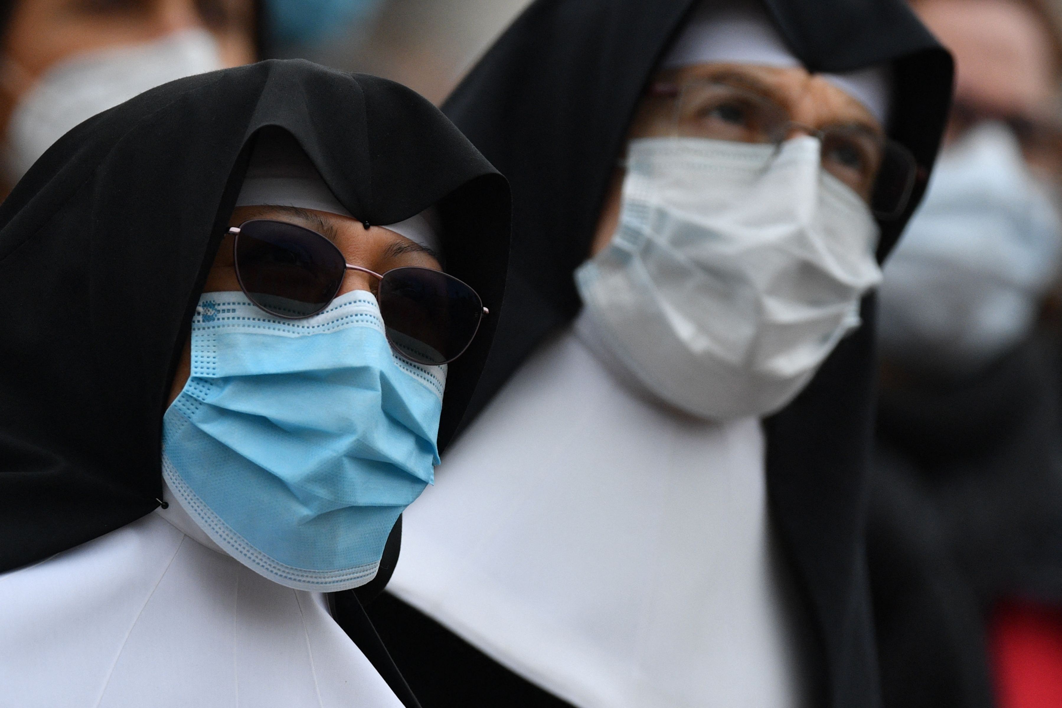 Para biarawati mengenakan masker saat menghadiri doa angelus mingguan Paus di Vatikan, Minggu (14/3). 