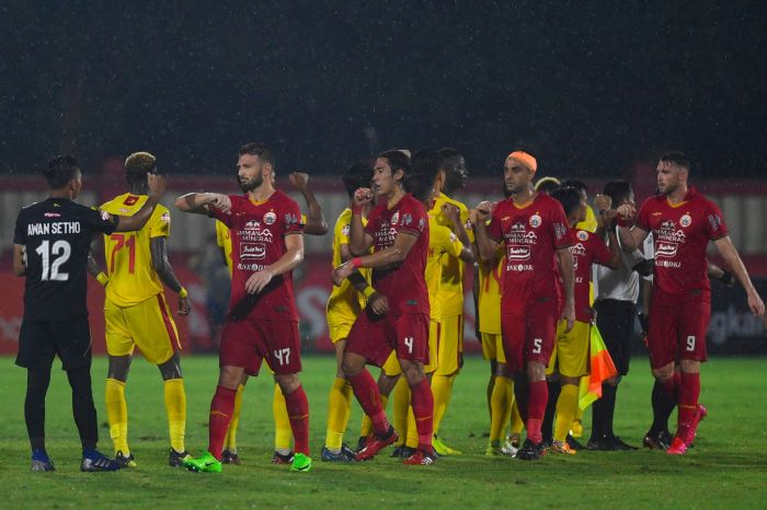 Pemain Persija (kostum merah) melakukan salam siku dengan pemain Bhayangkara FC tahun 2020.