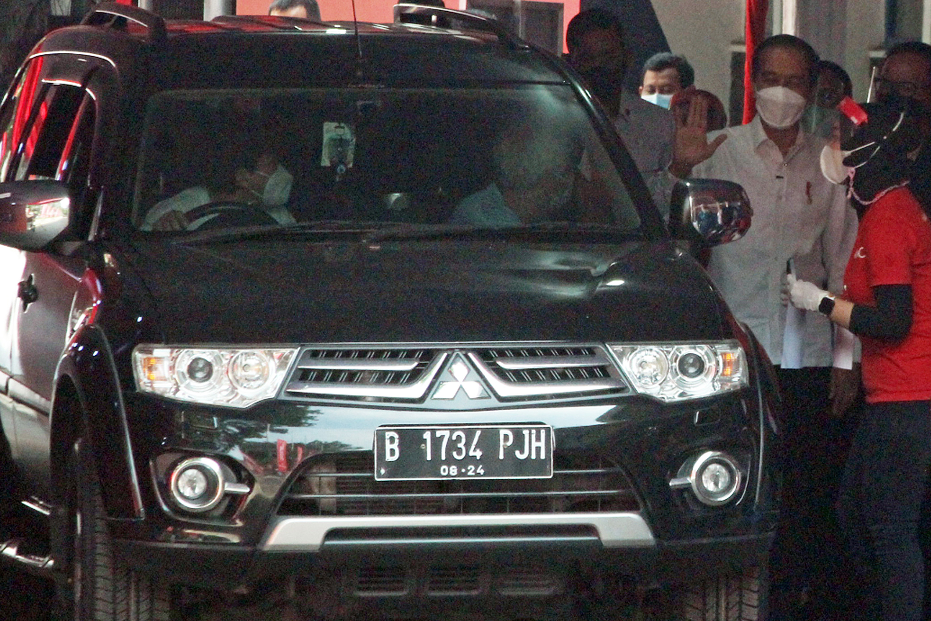 Presiden Joko Widodo (tengah) menyapa warga saat meninjau program vaksinasi drive through di halaman GOR Pajajaran, Kota Bogor, Jawa Barat.
