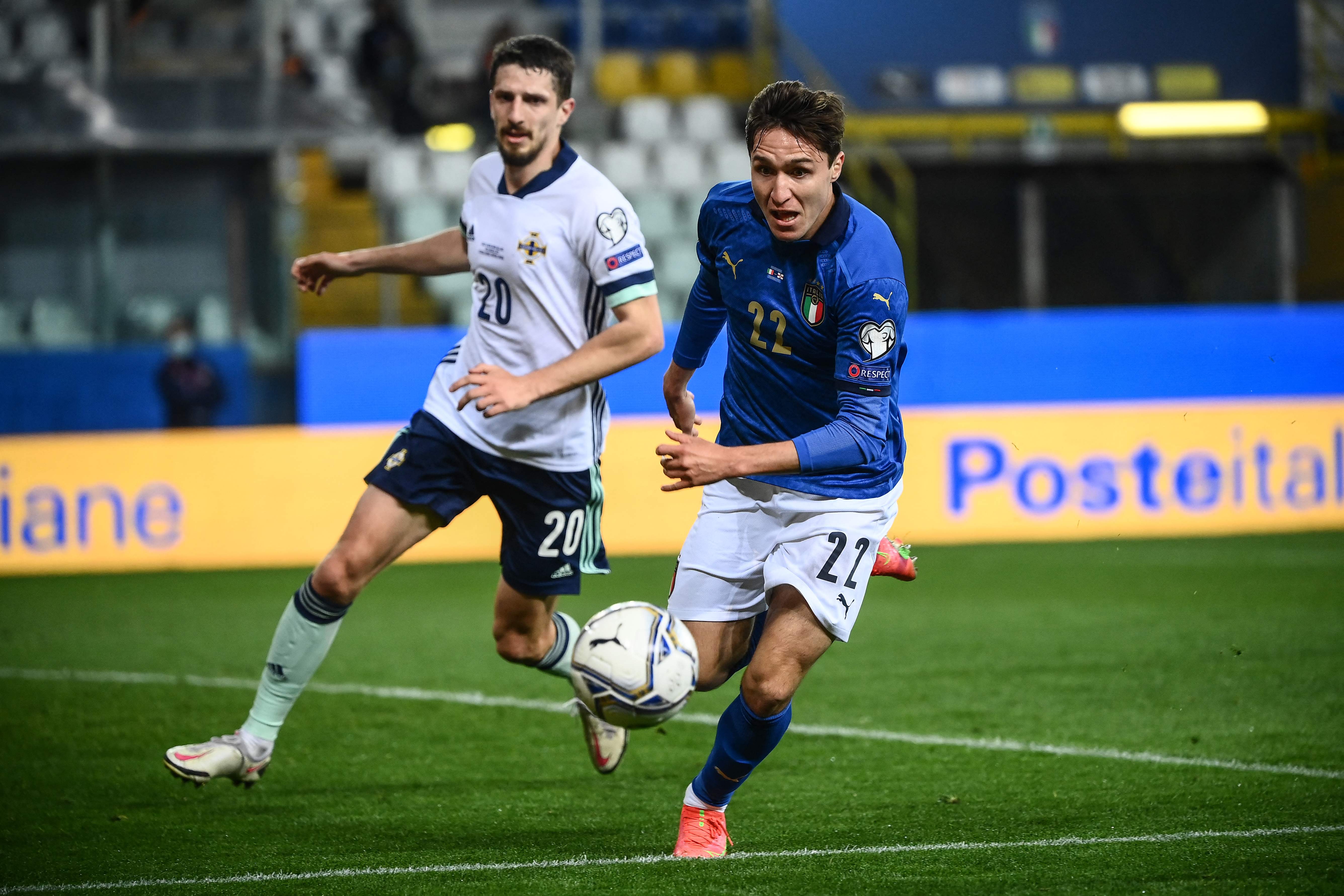 Penyerang tim Italia, Federico Chiesa (kanan) menggiring bola dengan dibayangi bek Irlandia Utara, Craig Cathcart.