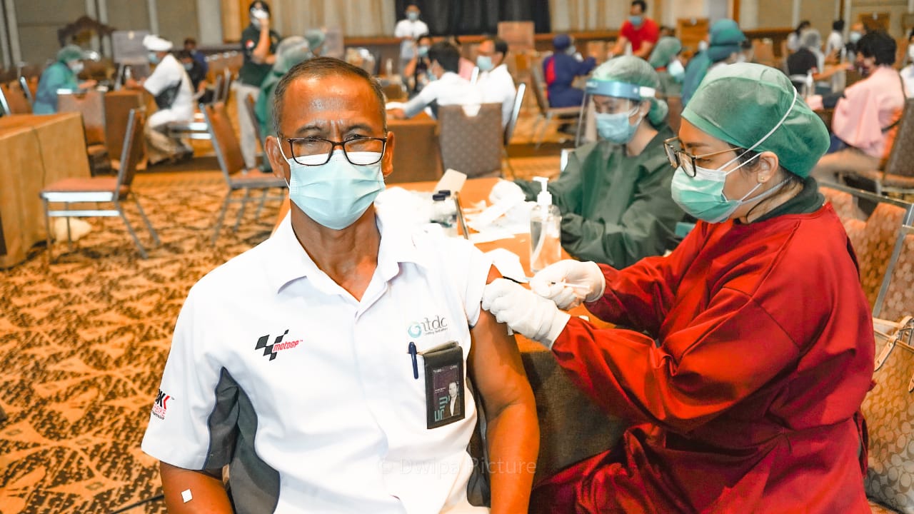 Seorang pria pekerja pariwisata tengah diberi vaksin.