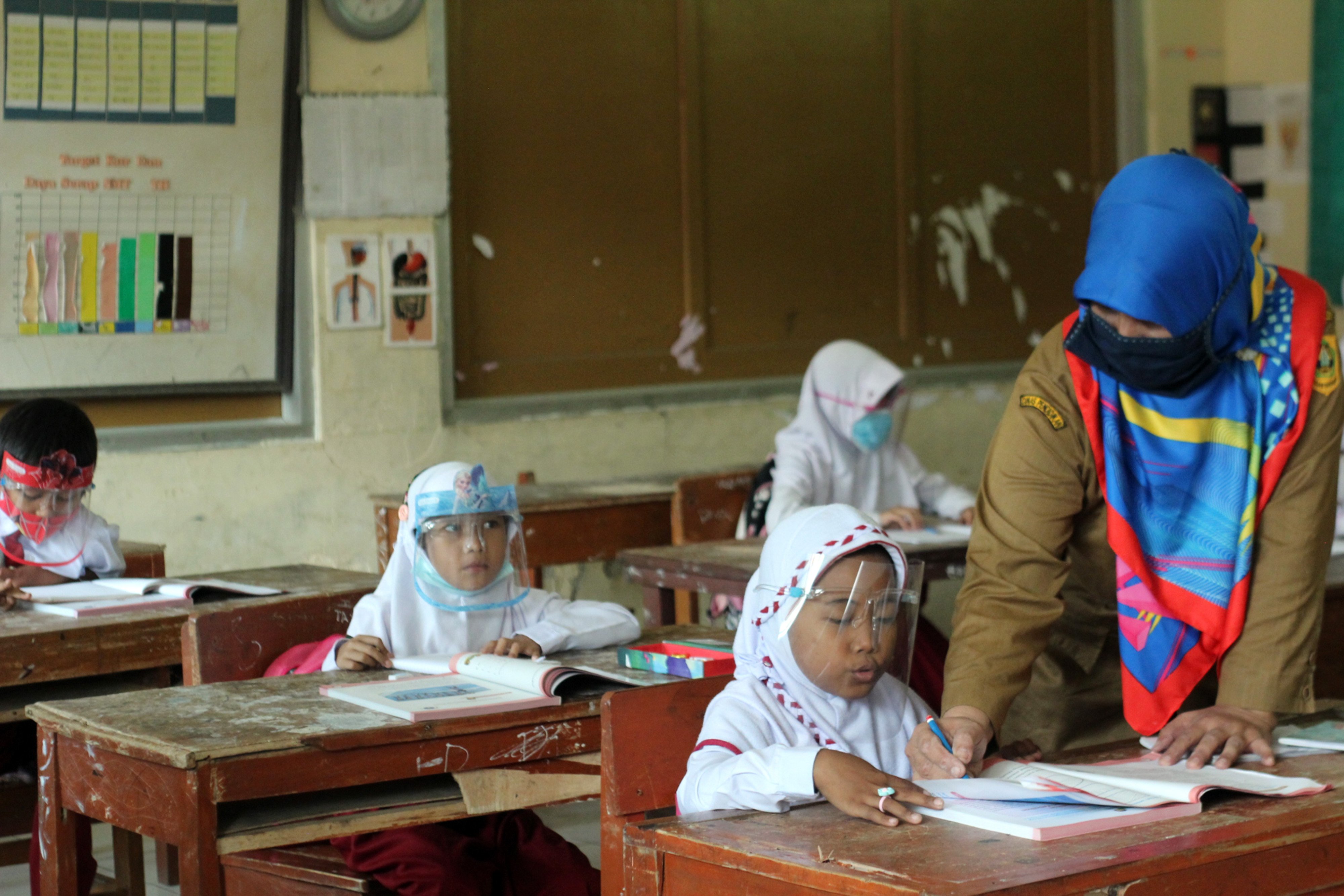 Guru menggunakan masker saat uji coba pembelajaran tatap muka di SDN Tegalwaru 02, Ciampea, Kabupaten Bogor, Jawa Barat, Senin (15/3/2021).