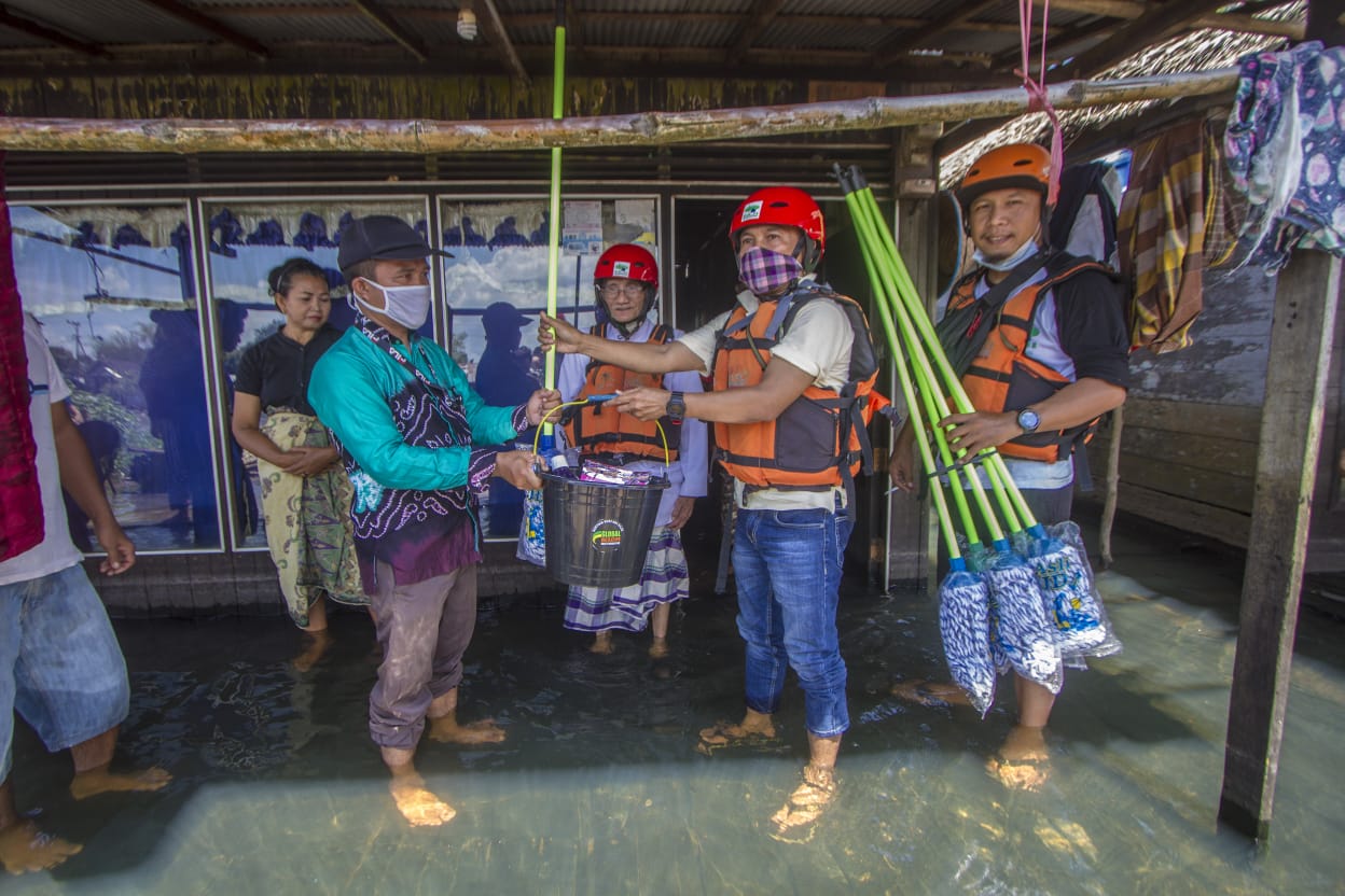 Petugas memberikan bantuan peralatan pembersih rumah yang direndam banjir di  Kabupaten Kotabaru, Kalimantan Selatan.