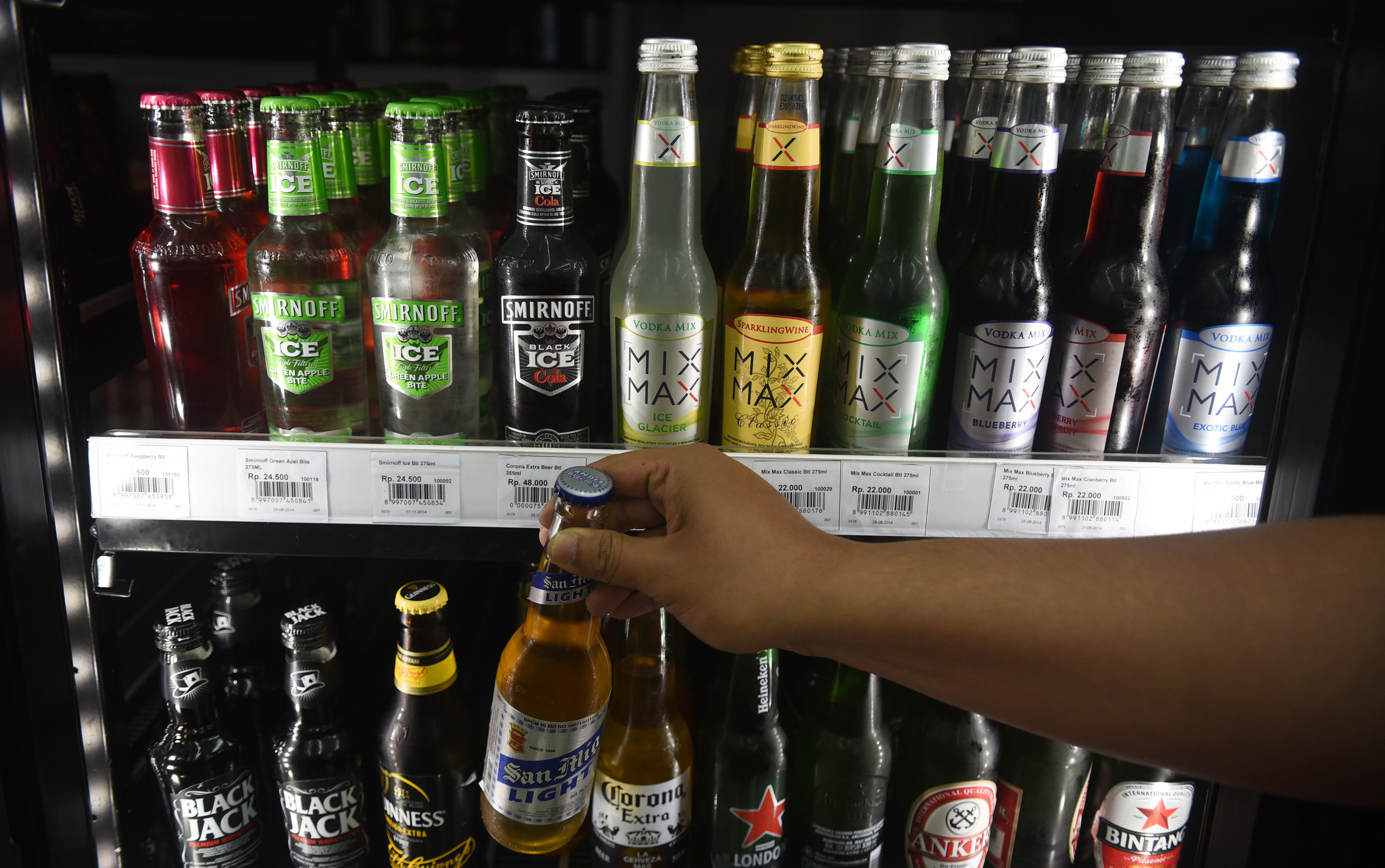 Konsumen mengambil sebotol minuman beralkohol di sebuah mini market di Jakarta.