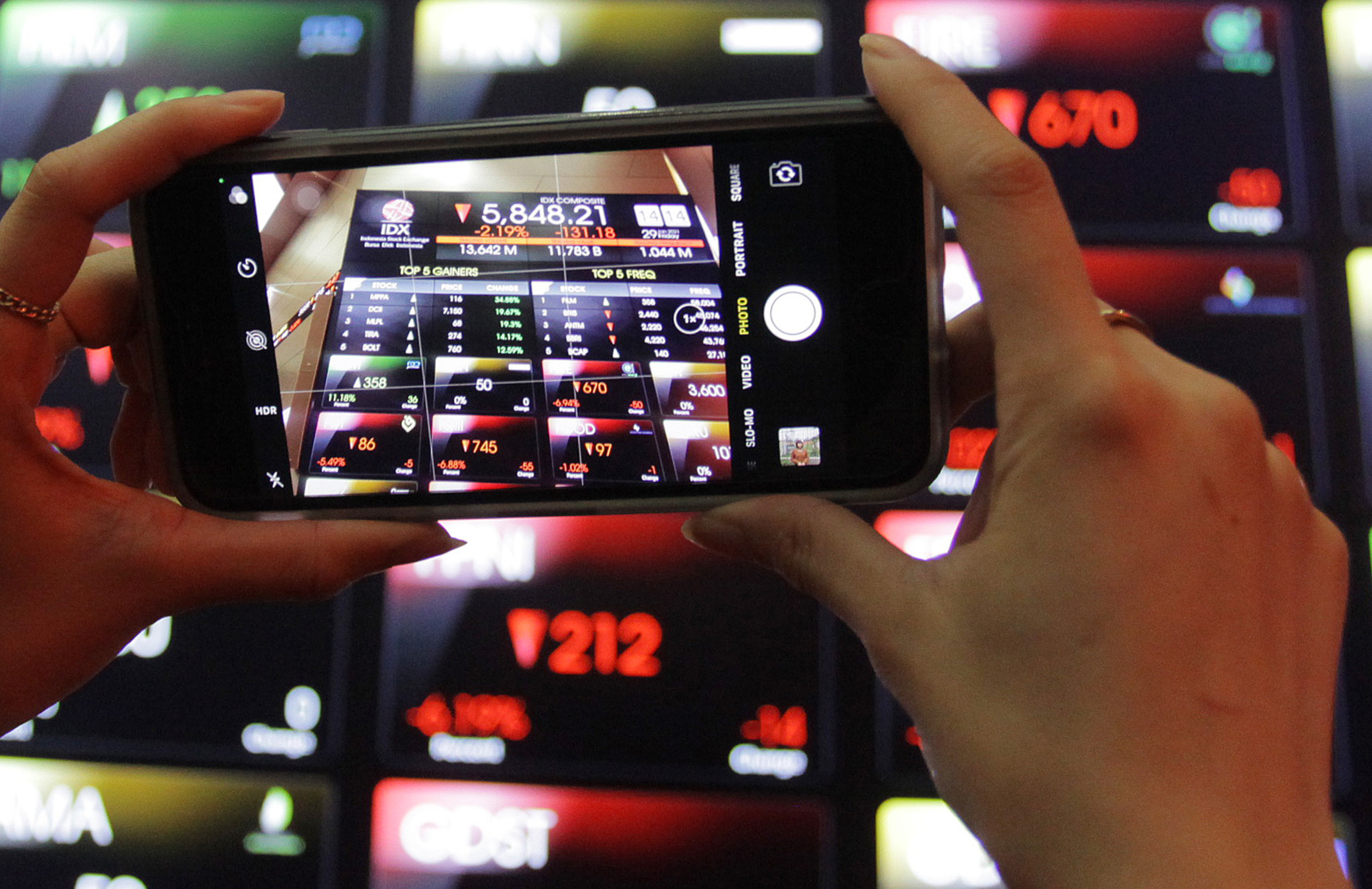 Karyawan memotret layar Indeks Harga Saham Gabungan (IHSG) di Bursa Efek Indonesia, Jakarta, Jumat (29/1).