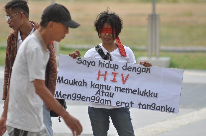 Peserta memegang poster saat mengikuti aksi peringatan Hari AIDS sedunia di Lapangan Vatulemo, Palu, Desember 2020.