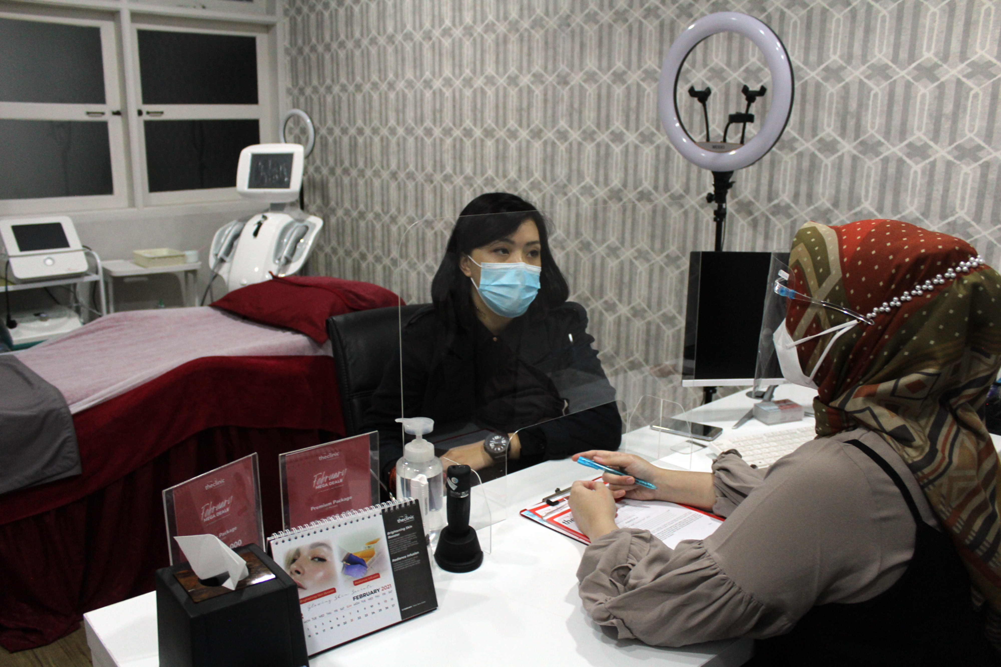 Pasien melakukan konsultasi dengan dokter saat perawatan kecantikan di sebuah salon.