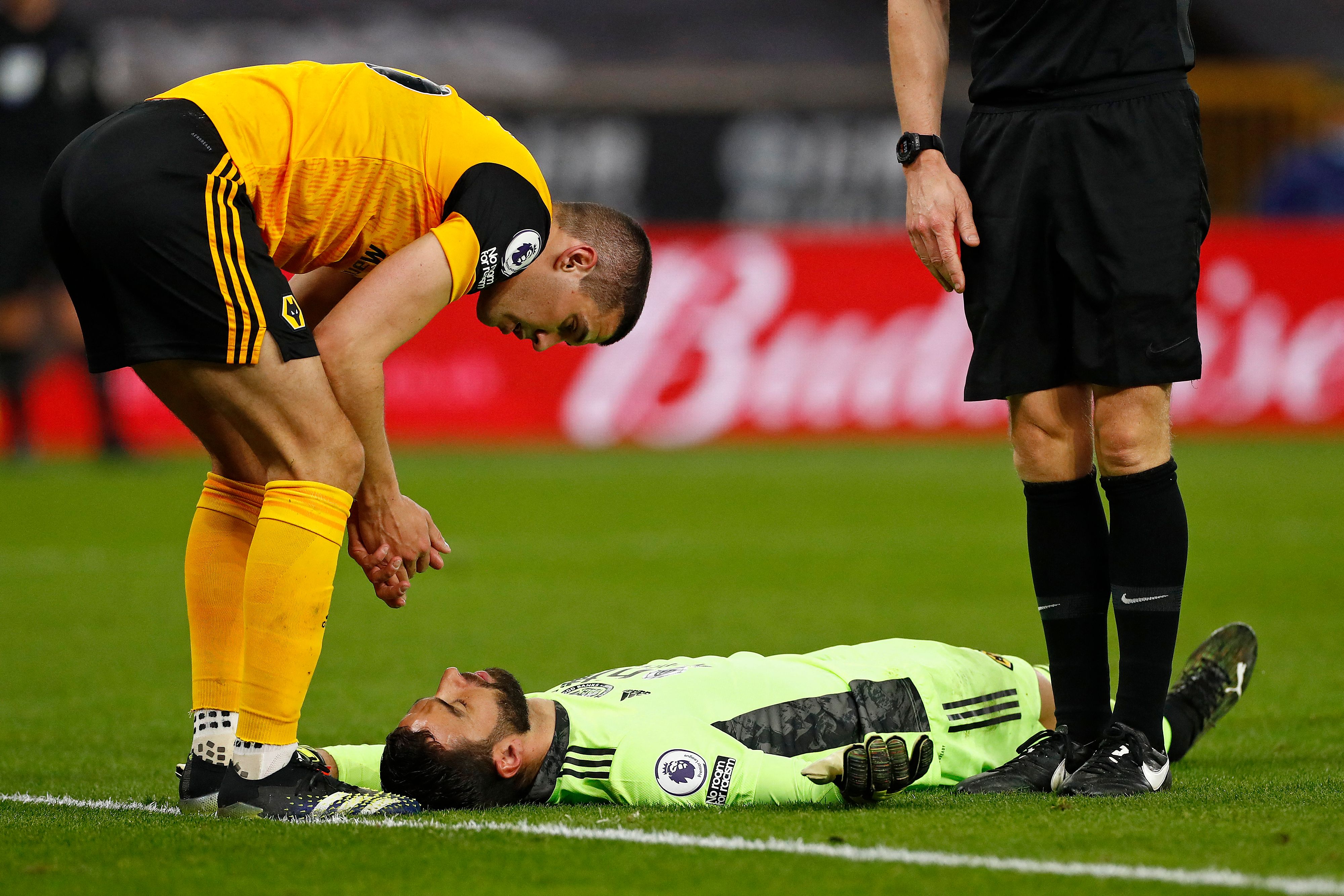 Kapten Wolverhampton Wanderers Connor Coady (kiri) berusaha menyadarkan kipernya Rui Patricio yang mengalami cedera kepala.