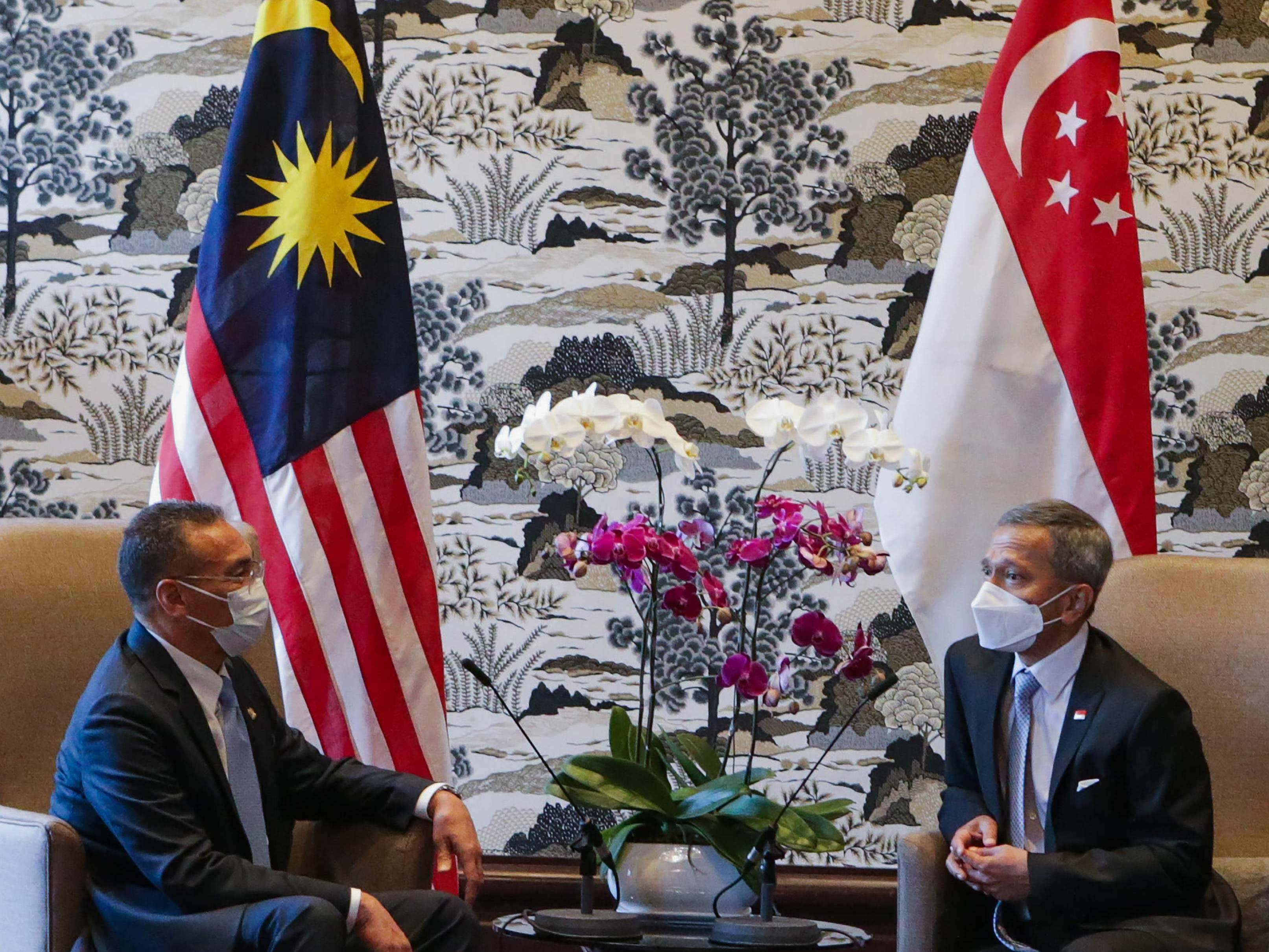 Menlu Malaysia Hishammuddin Hussein (kiri) berbicara dengan Menlu Singapura Vivian Balakrishnan di Putrajaya, Selasa (23/3).