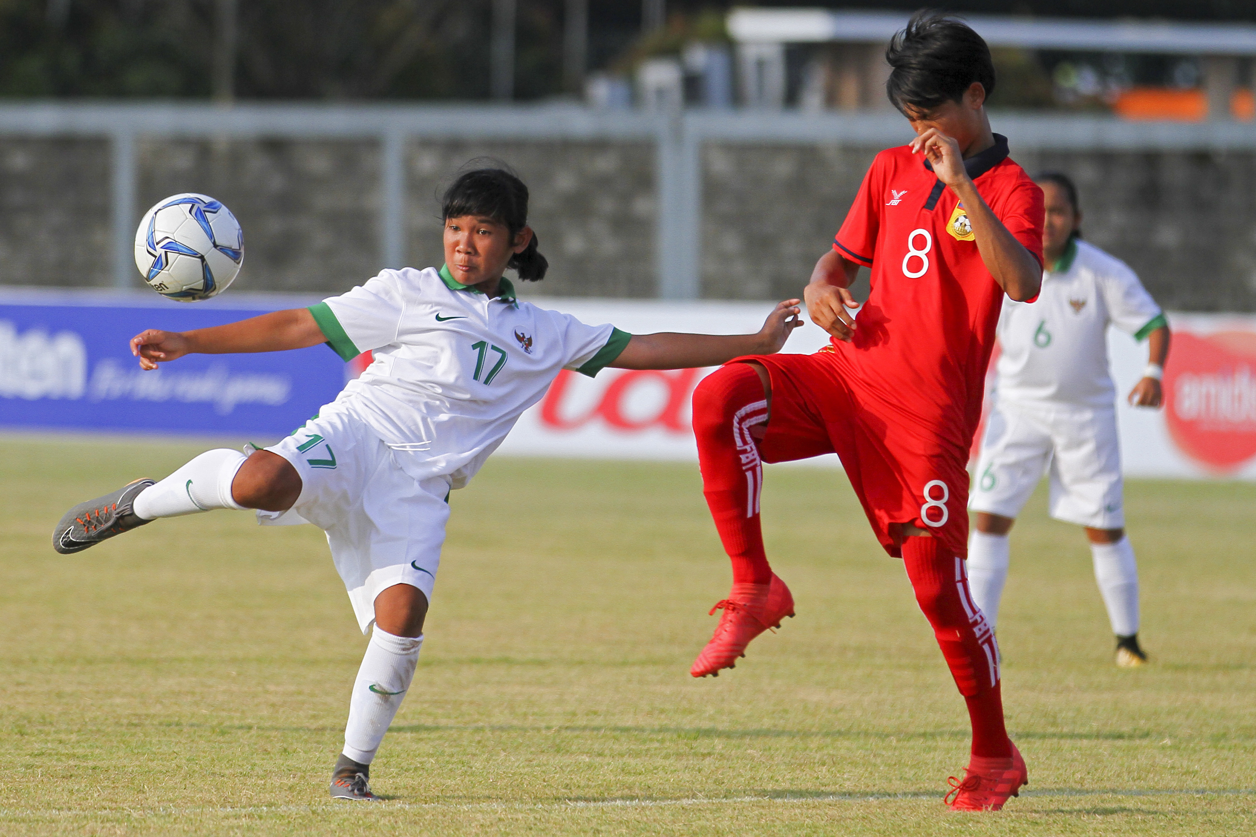 Pesepak bola Timnas Indonesia U-16 Wanita Azra Zifa Kayla (kiri) berebut bola dengan pesepak bola Timnas Laos U-16