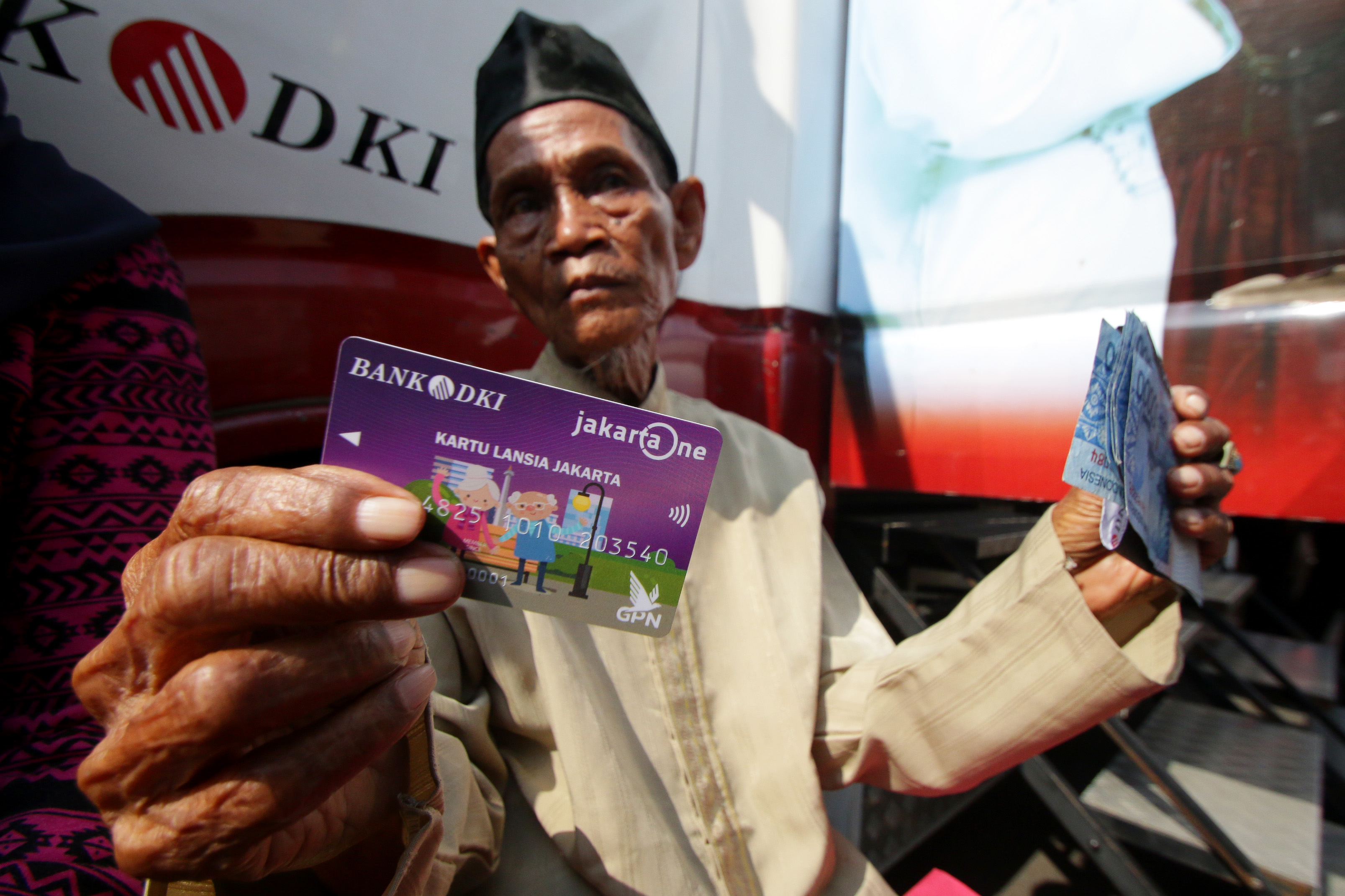 Warga menunjukkan Kartu Lansia Jakarta (KLJ) saat didistribusikan di RPTRA Tanah Tinggi, Johar Baru, Jakarta
