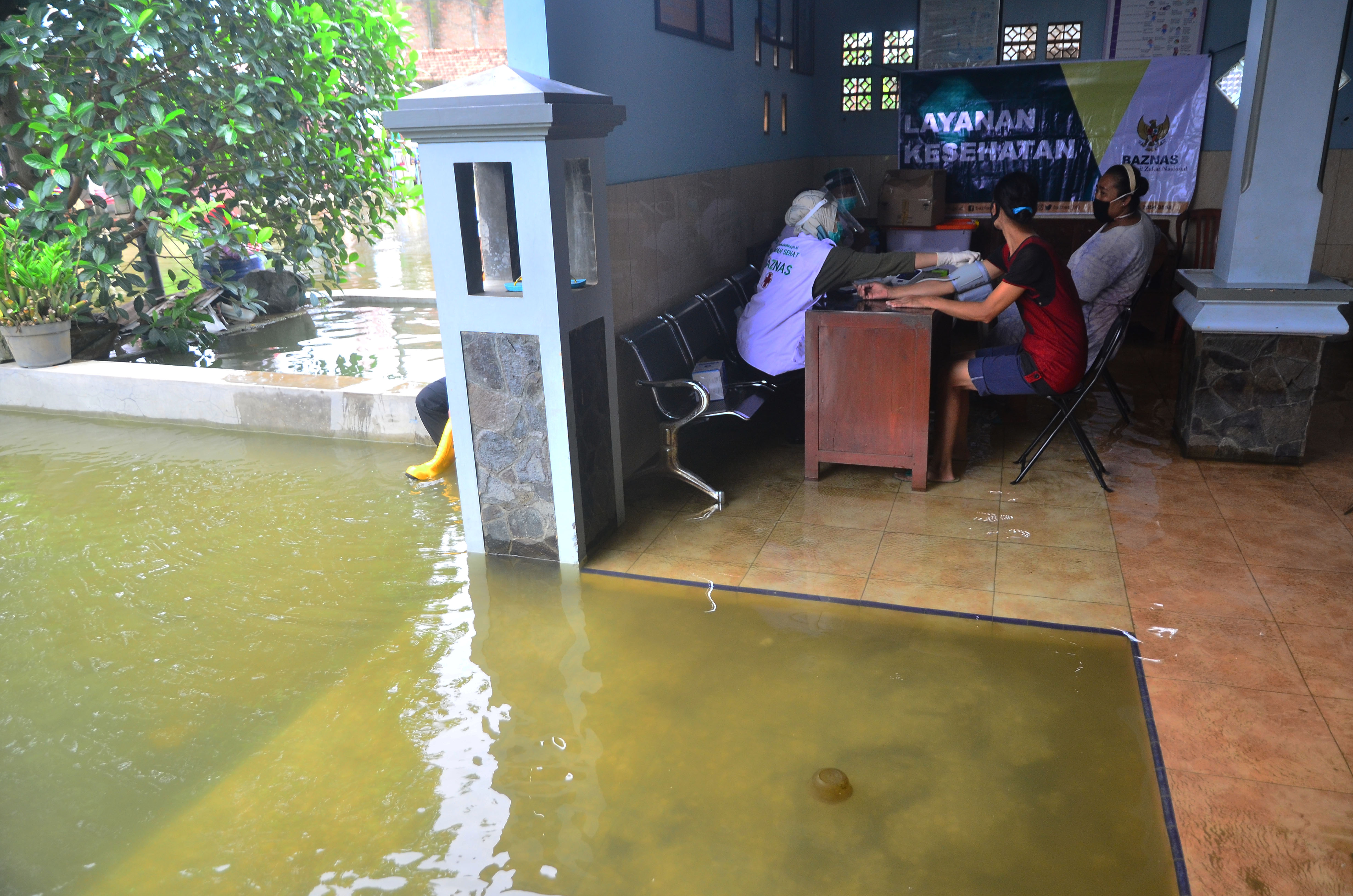 Petugas memeriksa warga saat pengobatan gratis yang digelar Baznas di Dukuh Setrokalangan, Kaliwungu, Kudus, Jawa Tengah, Rabu (3/2/2021)