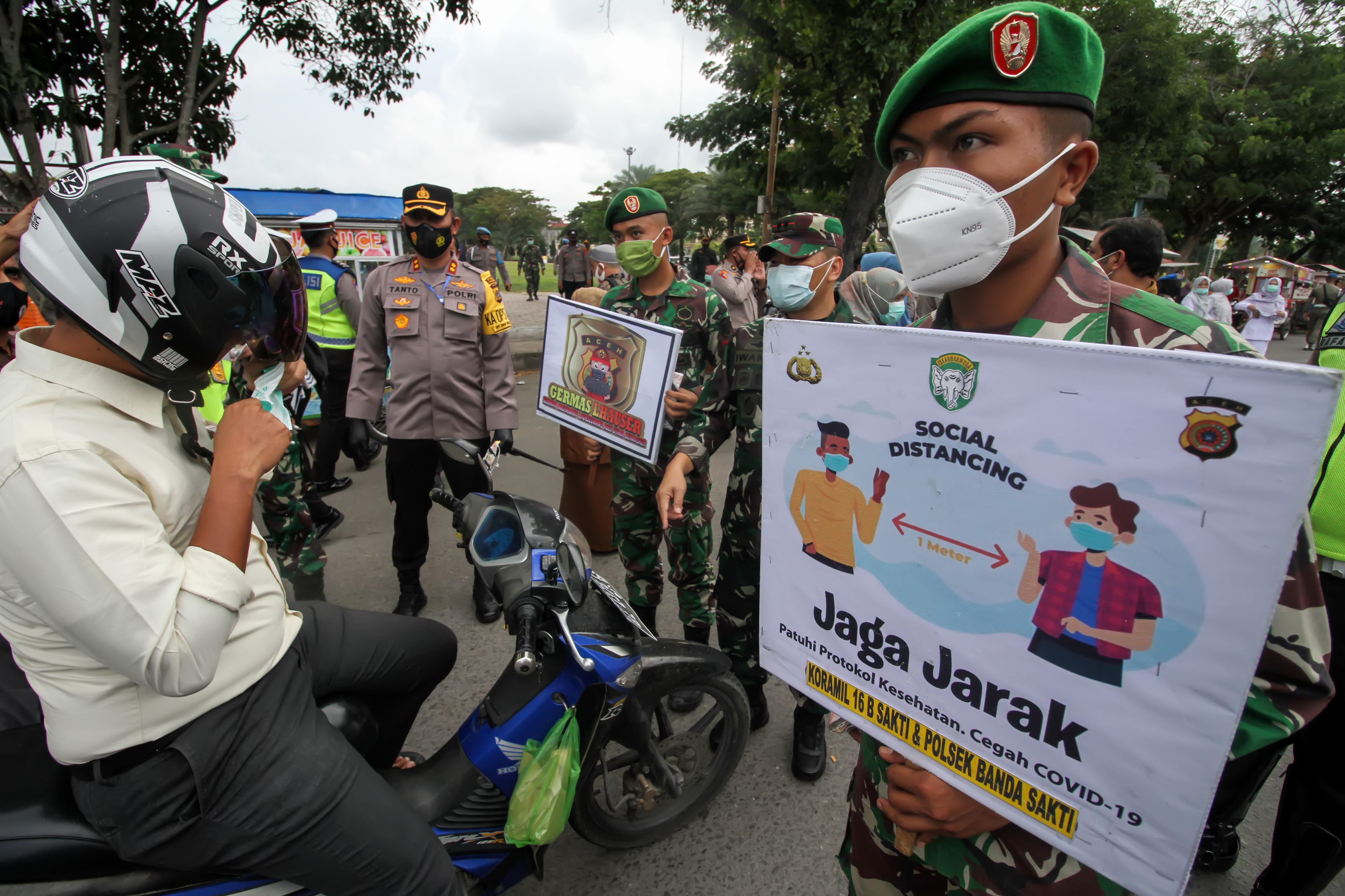 Petugas gabungan TNI dan Polri menjaring warga tidak menggunakan masker saat berlangsung gerakan pakai masker di Lhok Seumawe, Aceh.