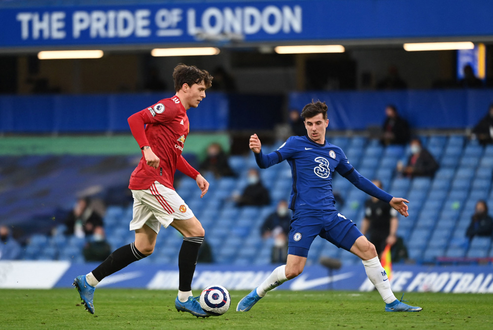 Pemain Manchester United Victor Lindelof (kiri) berusaha melewati pemain Chelsea Mason Mount dalam lanjutan Liga Primer, Senin (1/3).  