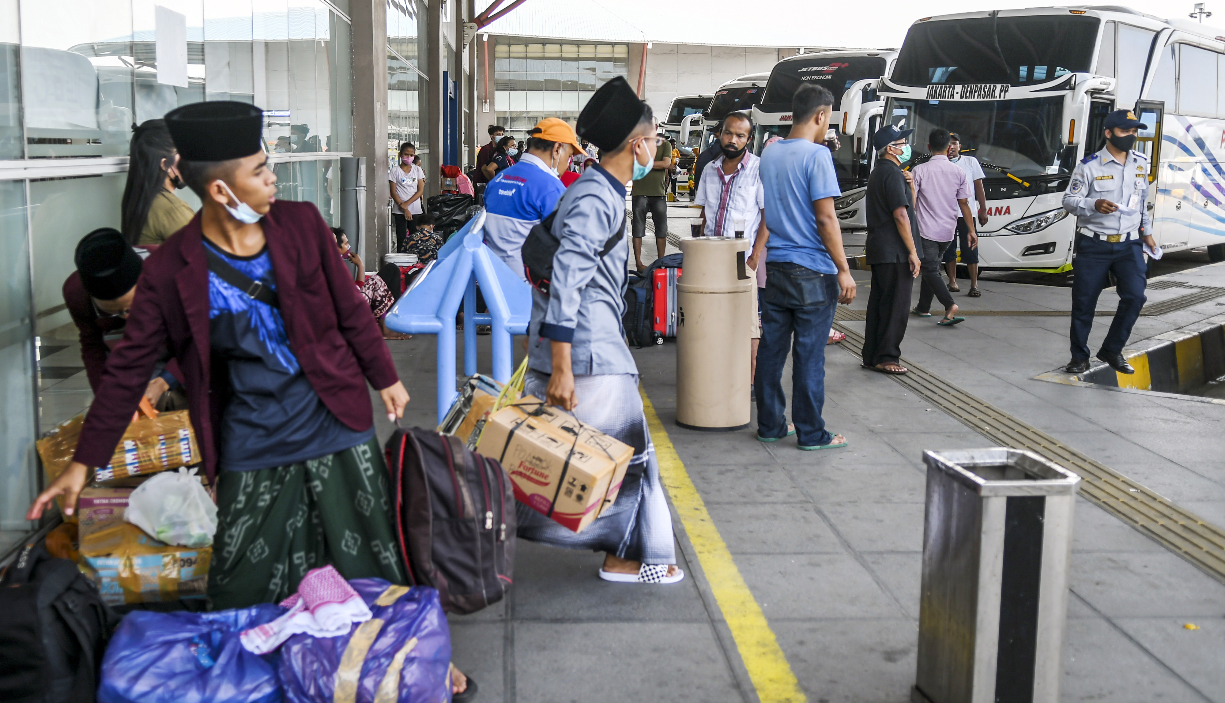 Calon penumpang bersiap menaiki bus di Terminal Terpadu Pulo Gebang, Jakarta, Jumat (26/3/2021)