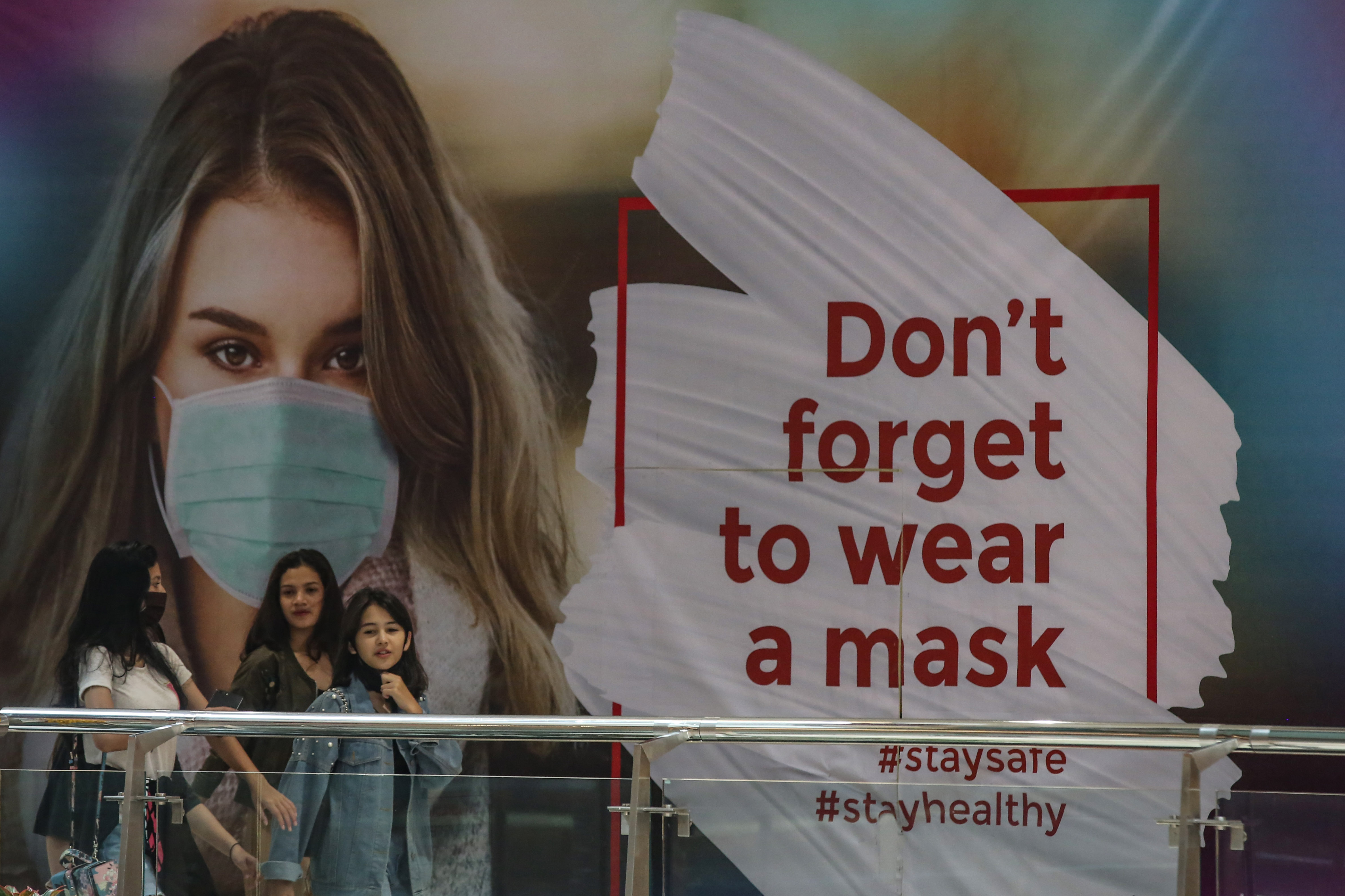 Poster sosialisasi untuk menggunakan masker saat beraktivitas di kawasan Jakarta.