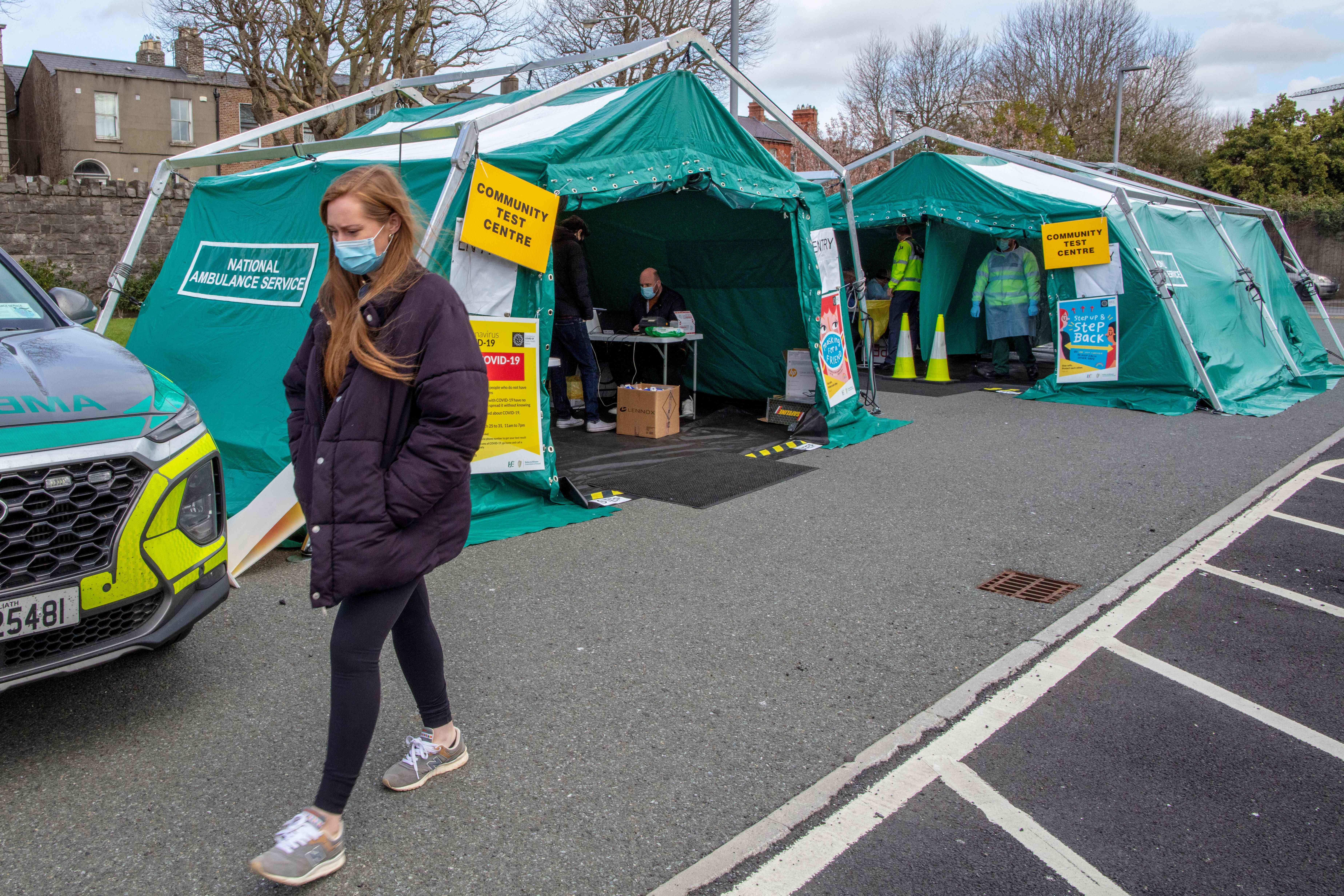 Seorang warga melintas di depan tenda pengujian covid-19 di Dublin, Irlandia.