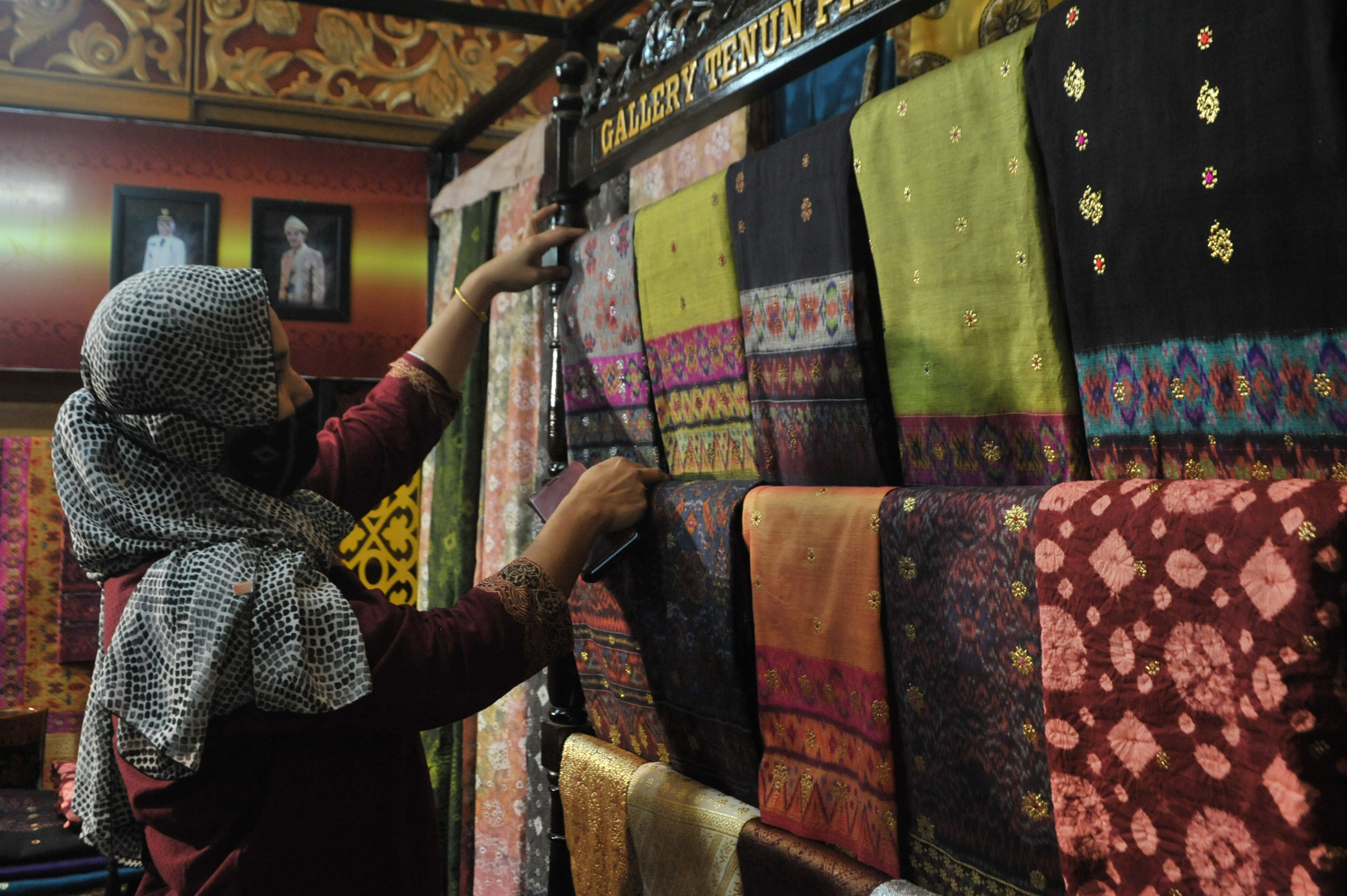  Pelaku usaha merapikan kain saat Pameran Dekranasda se-Sumtera Selatan di Sumatera Selatan, Kamis (4/3).