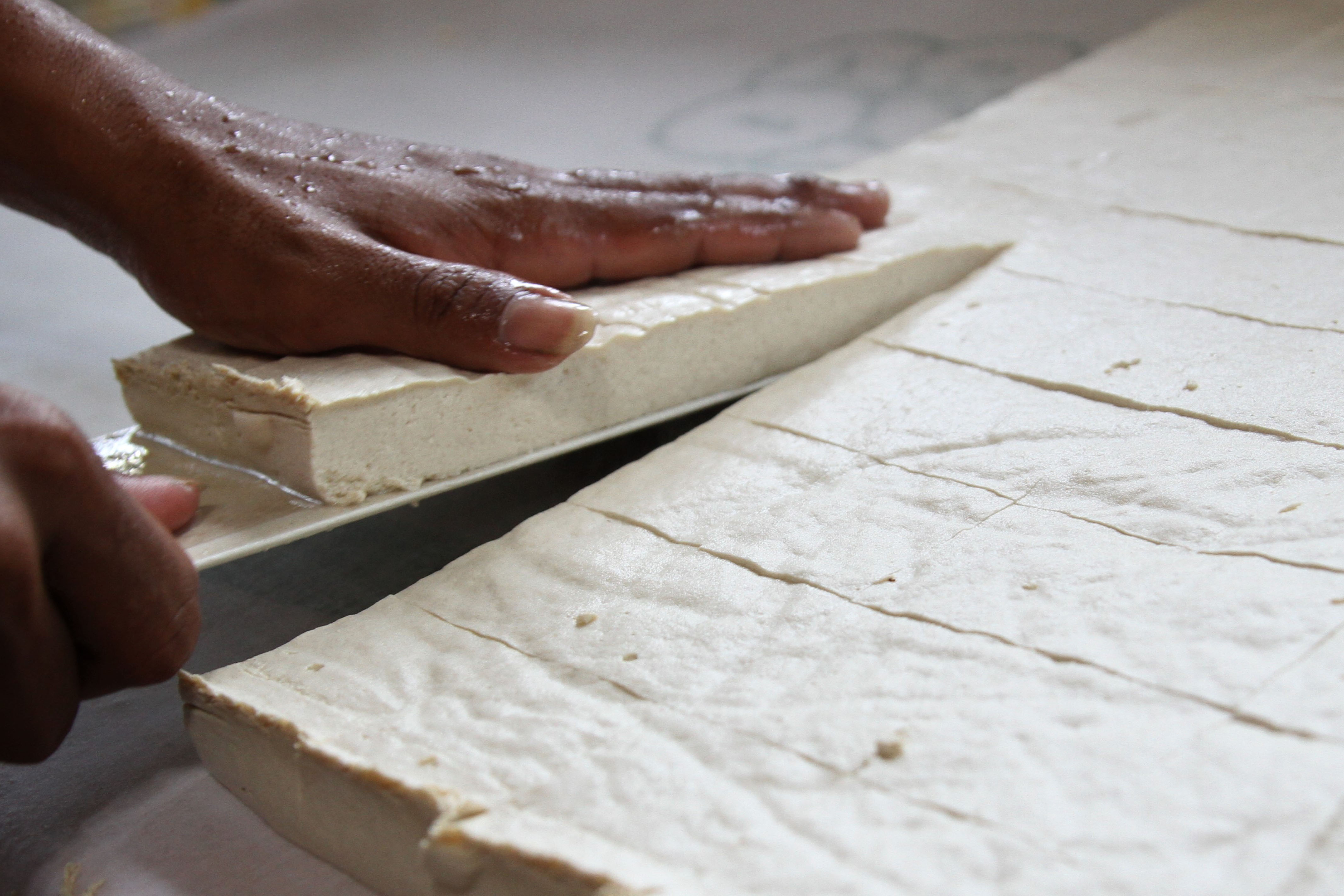 Perajin memotong tahu