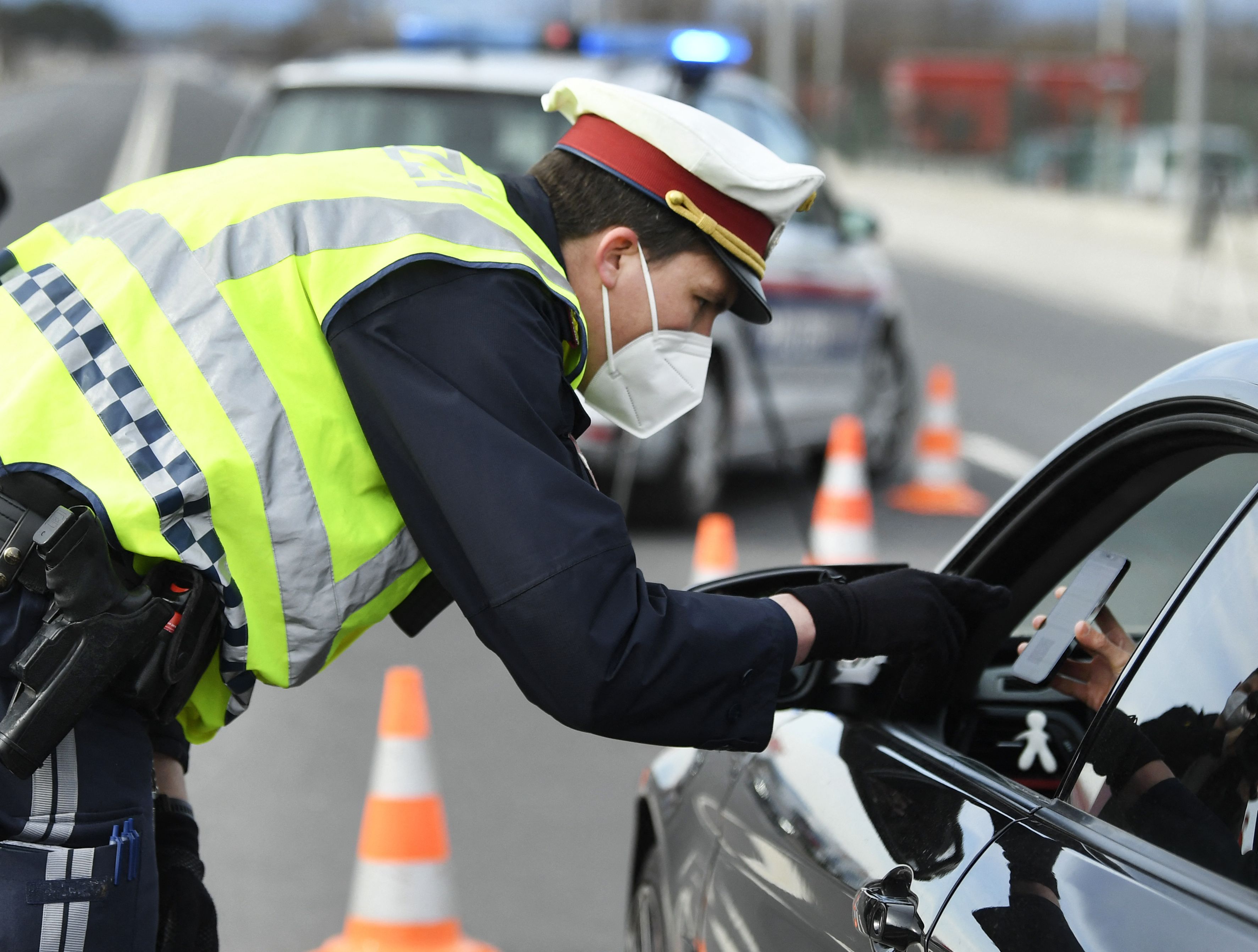 Polisi Austria memeriksa pengemudi mobil di pos pemeriksaan demi menekan angka penyebaran covid-19.