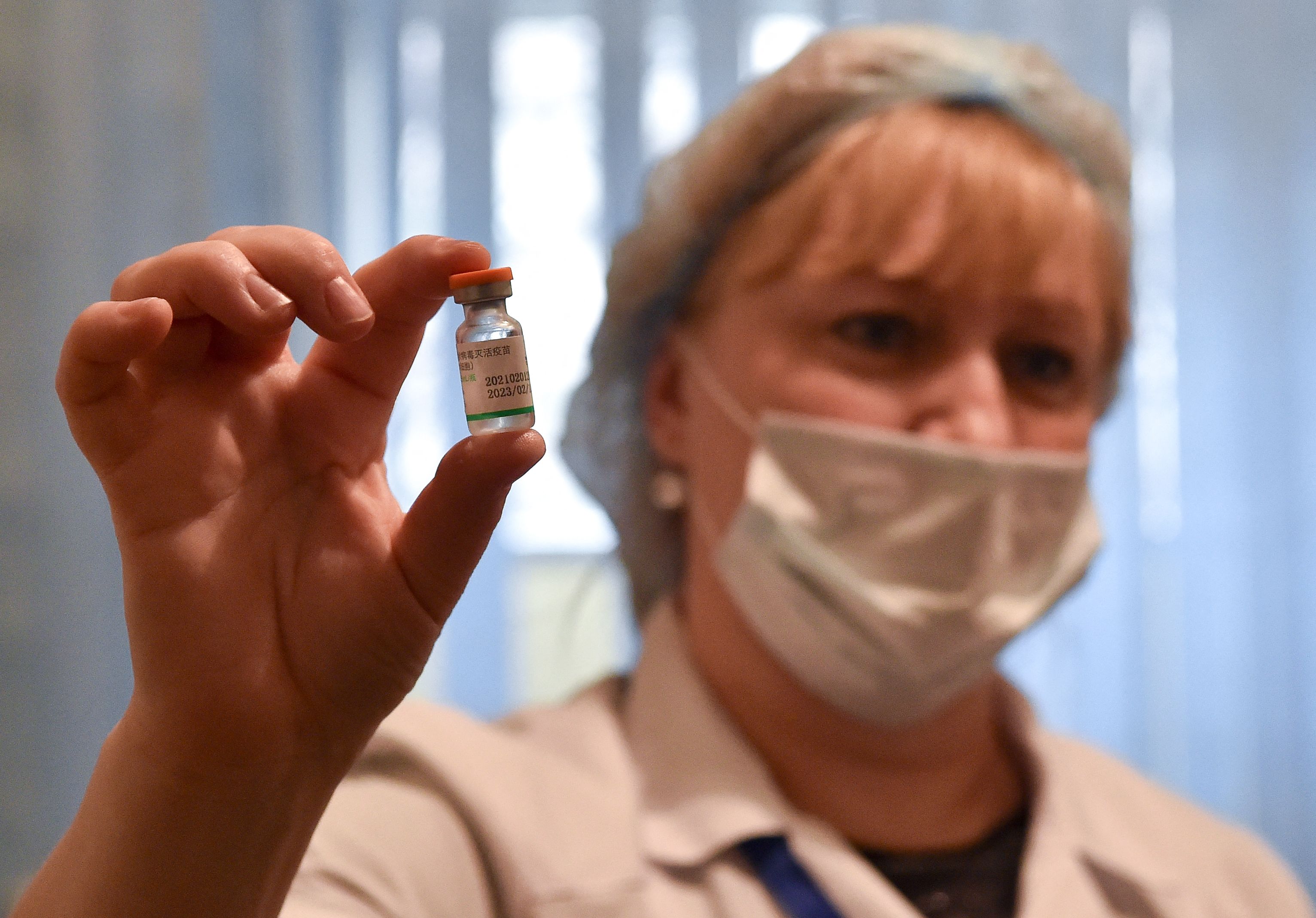 Seorang petugas medis menunjukkan botol berisi vaksin covid-19 Sinopharm.