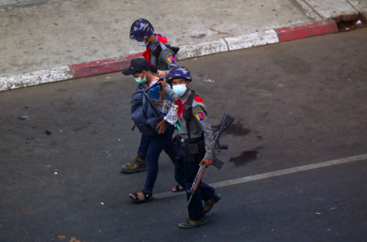 Polisi menangkap jurnalis Myanmar di Yangon pada 27 Februari 2021.