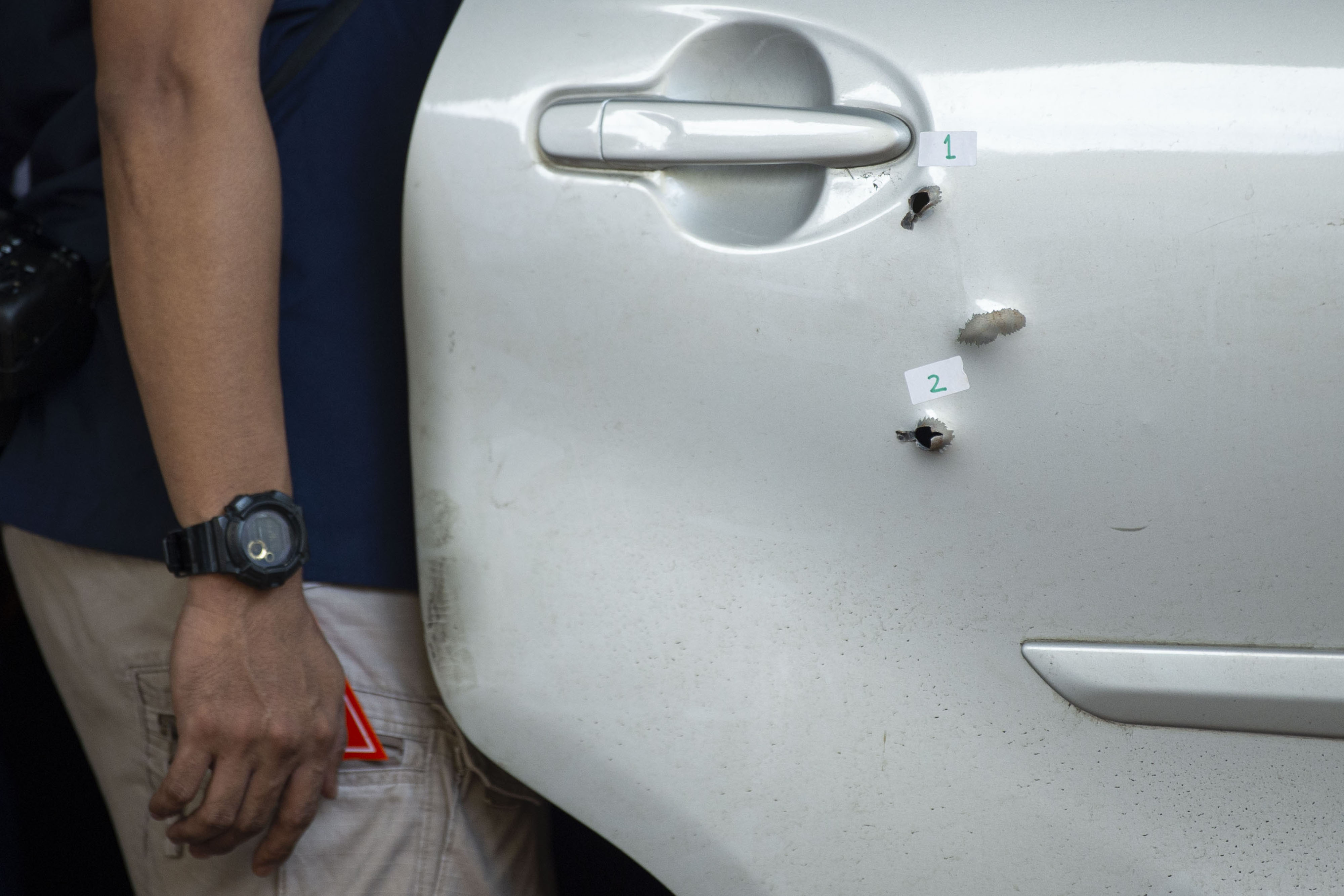 Lubang peluru akibat tembakan di mobil yang dikendarai polisi.