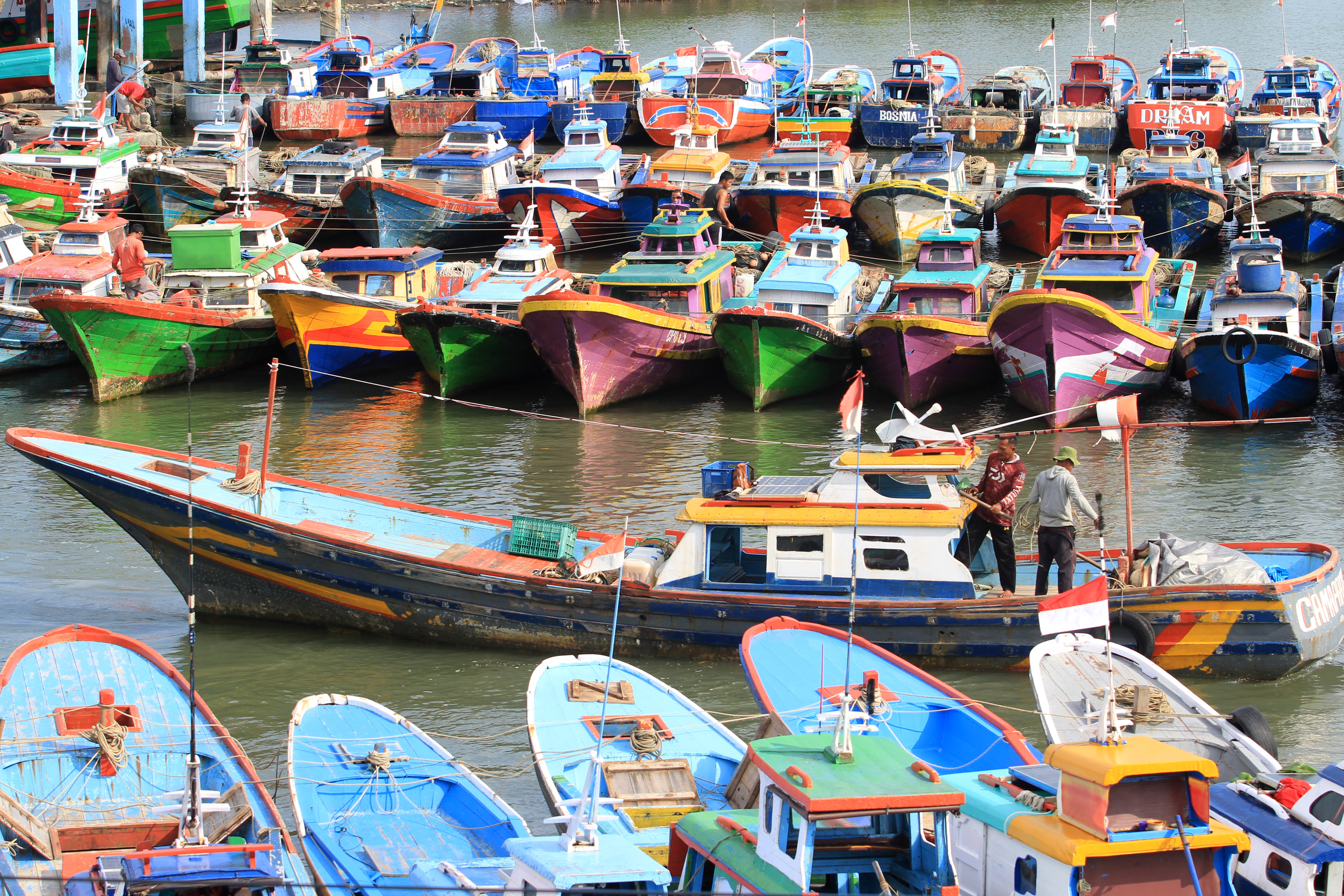Nelayan menambatkan kapal motornya saat tidak melaut akibat gelombang tinggi di pelabuhan Desa Kuala Bubon, Samatiga, Aceh, Rabu (17/2/2021)