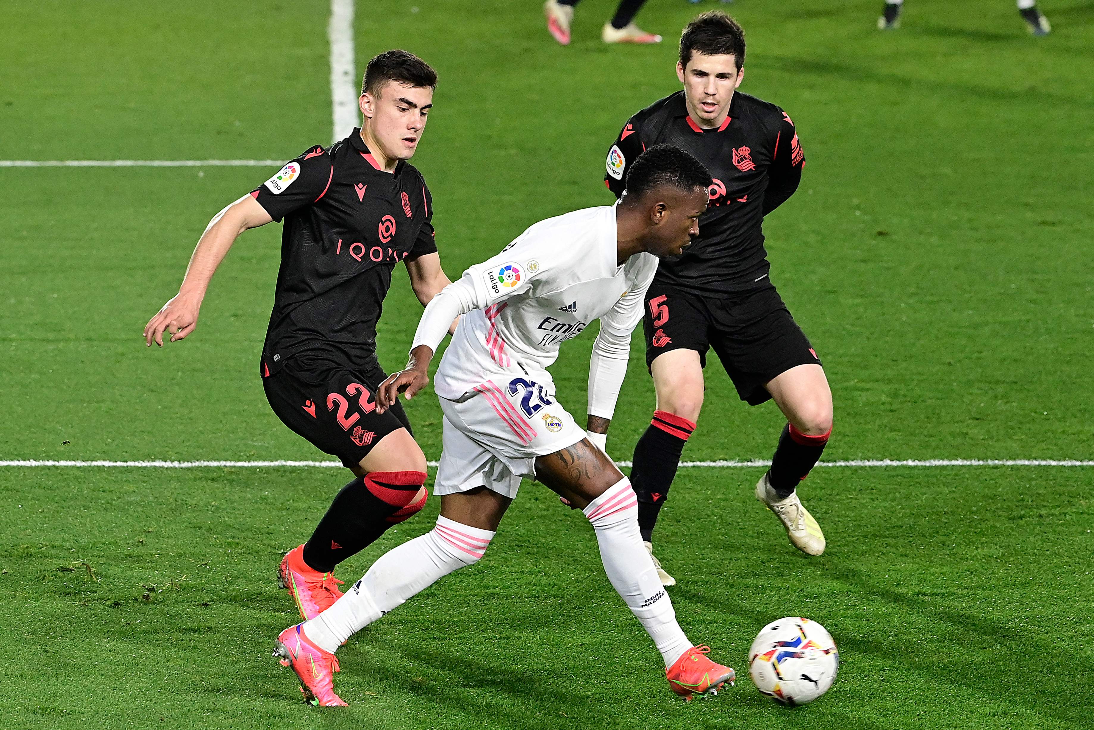 Penyerang Real Madrid Vinicius Junior (tengah) dibayangi penyerang Real Sociedad Ander Barrenetxea (kiri) dan gelandang Igor Zubeldia. 