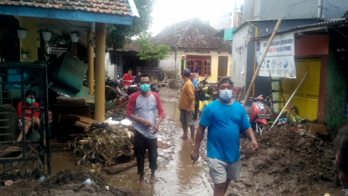 BANJIR BANDANG: Banjir bandang terjadi di sejumlah daerah di Indonesia. Petugas BPBD dan warga membersihkan lumpur di lokasi banjir bandang.