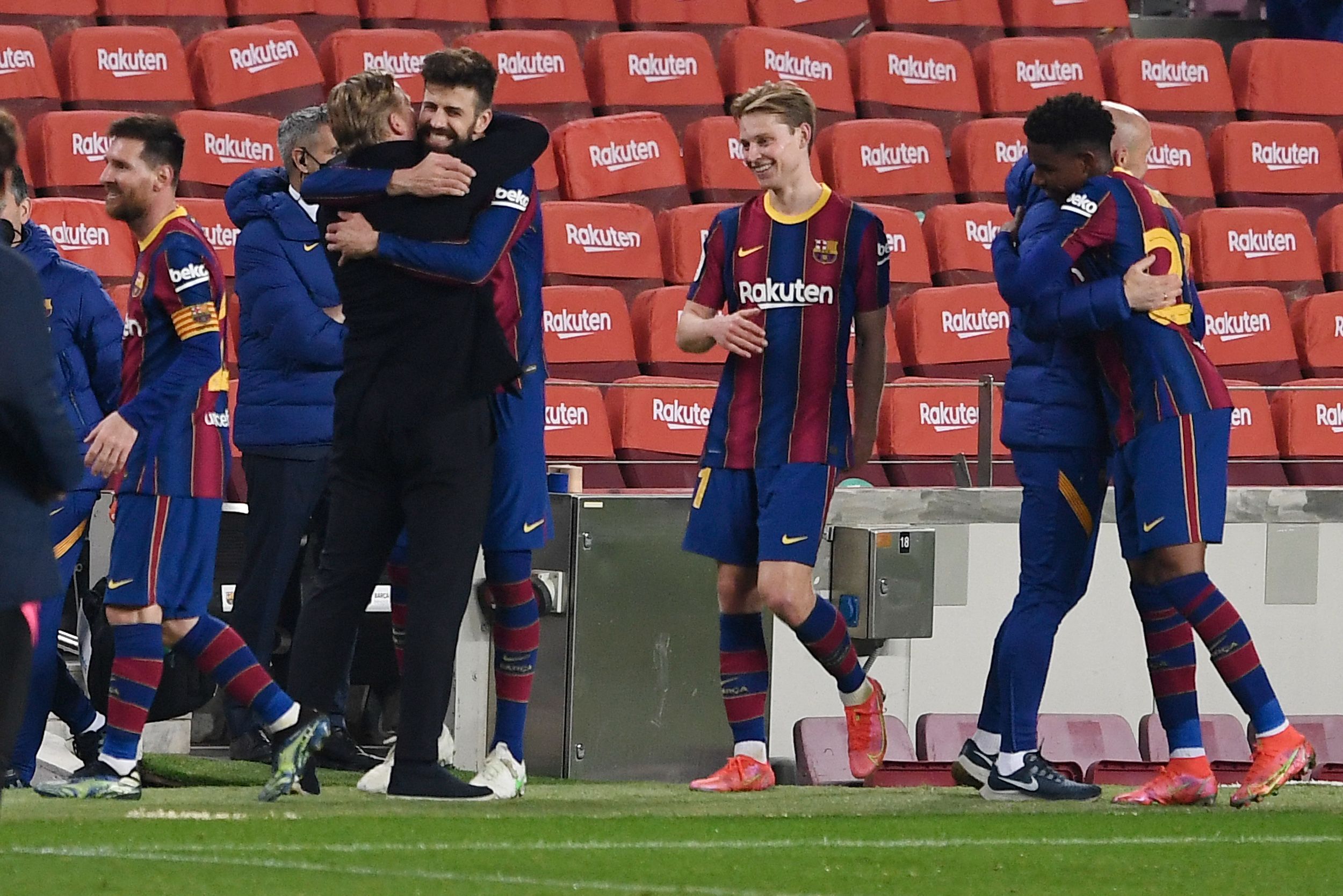 Pelatih Barcelona berangkulan dengan bek Gerard Pique setelah timnya mengalahkan Sevilla 3-0 dan lolos ke final Copa del Rey.  