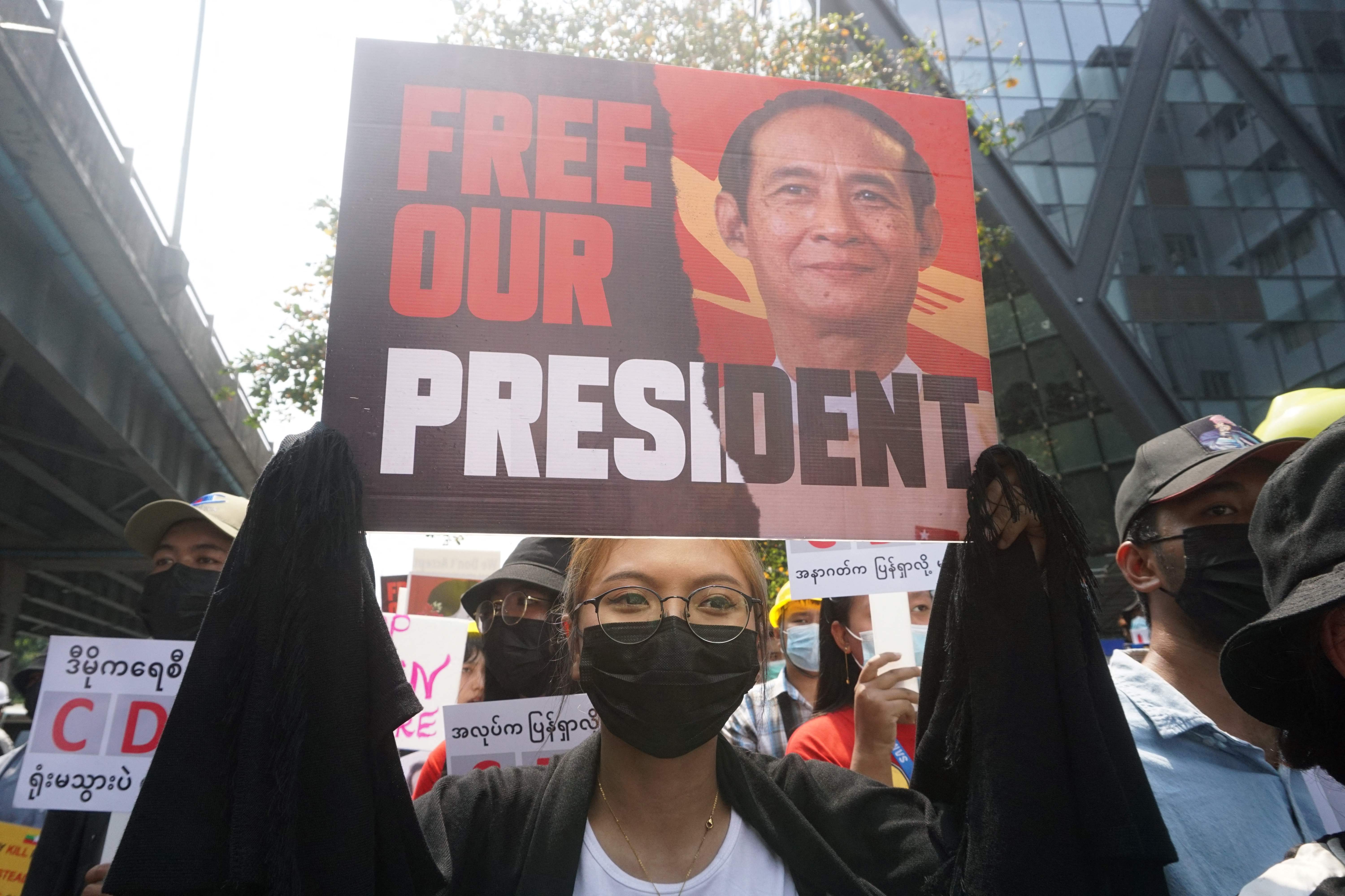 Demonstran membawa poster Presiden Myanmar yang dikudeta oleh militer