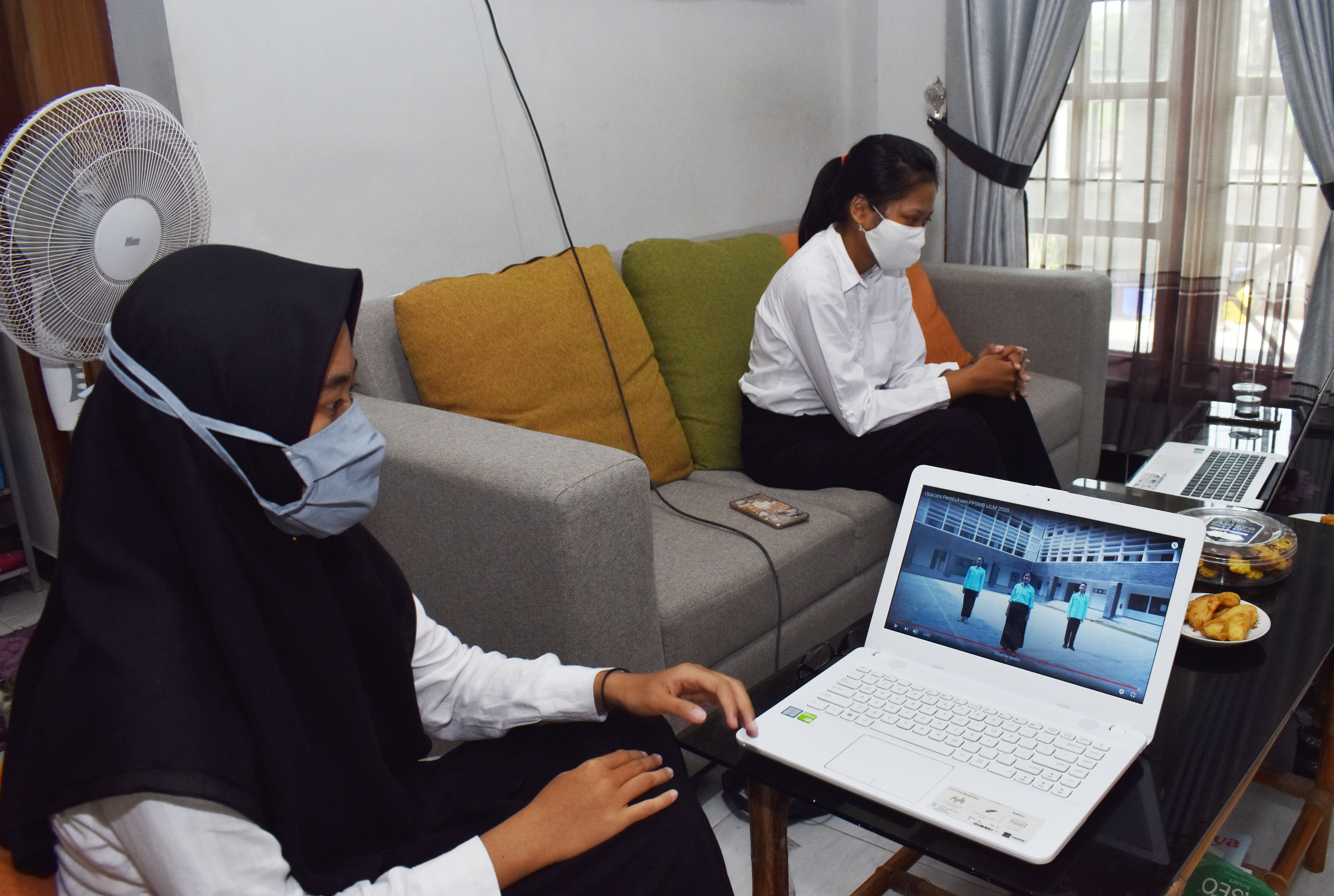 Dua orang mahasiswi baru Universitas Gadjah Mada (UGM) Yogyakarta mengikuti Orientasi Studi dan Pengenalan Kampus (Opspek) secara daring di 