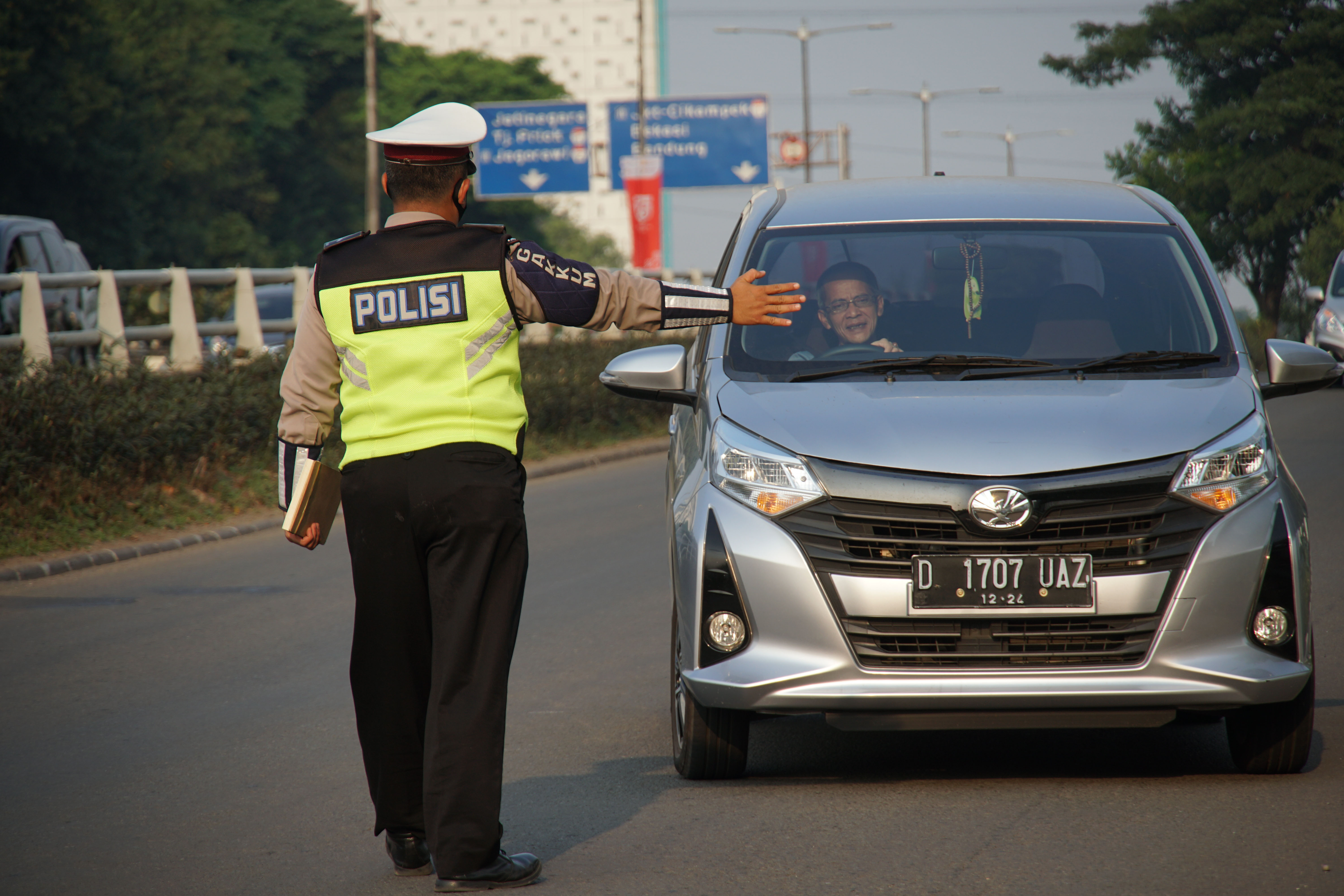 Polantas memberhentikan mobil yang melanggar aturan ganjil genap di Jalan Letjen MT Haryono, Jakarta.