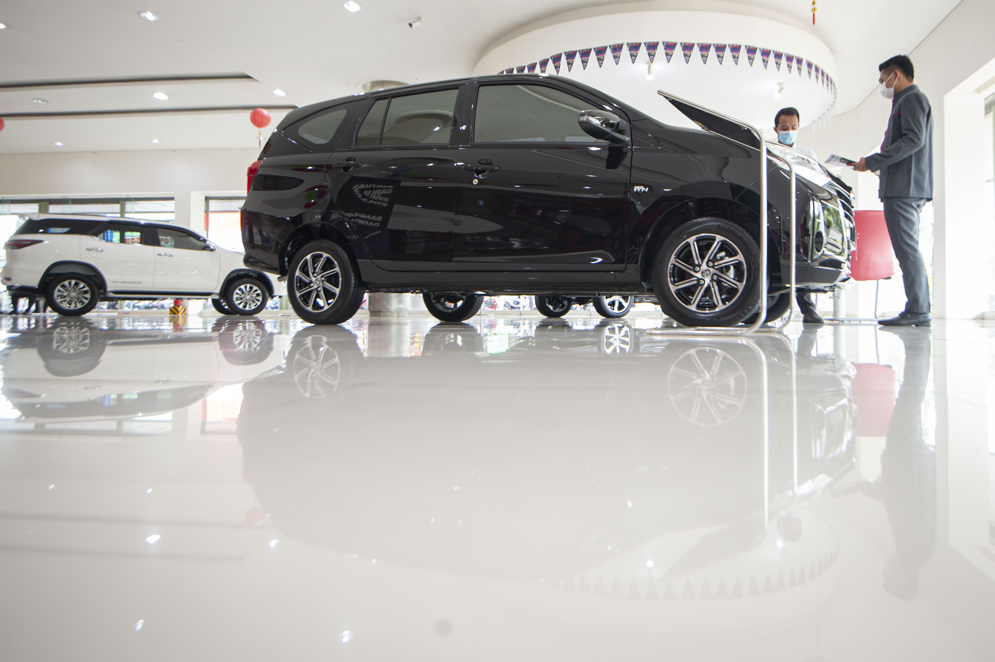 Karyawan menjelaskan salah satu produk mobil kepada calon pembeli di salah satu dealer di Jakarta, Senin (15/2/2021).