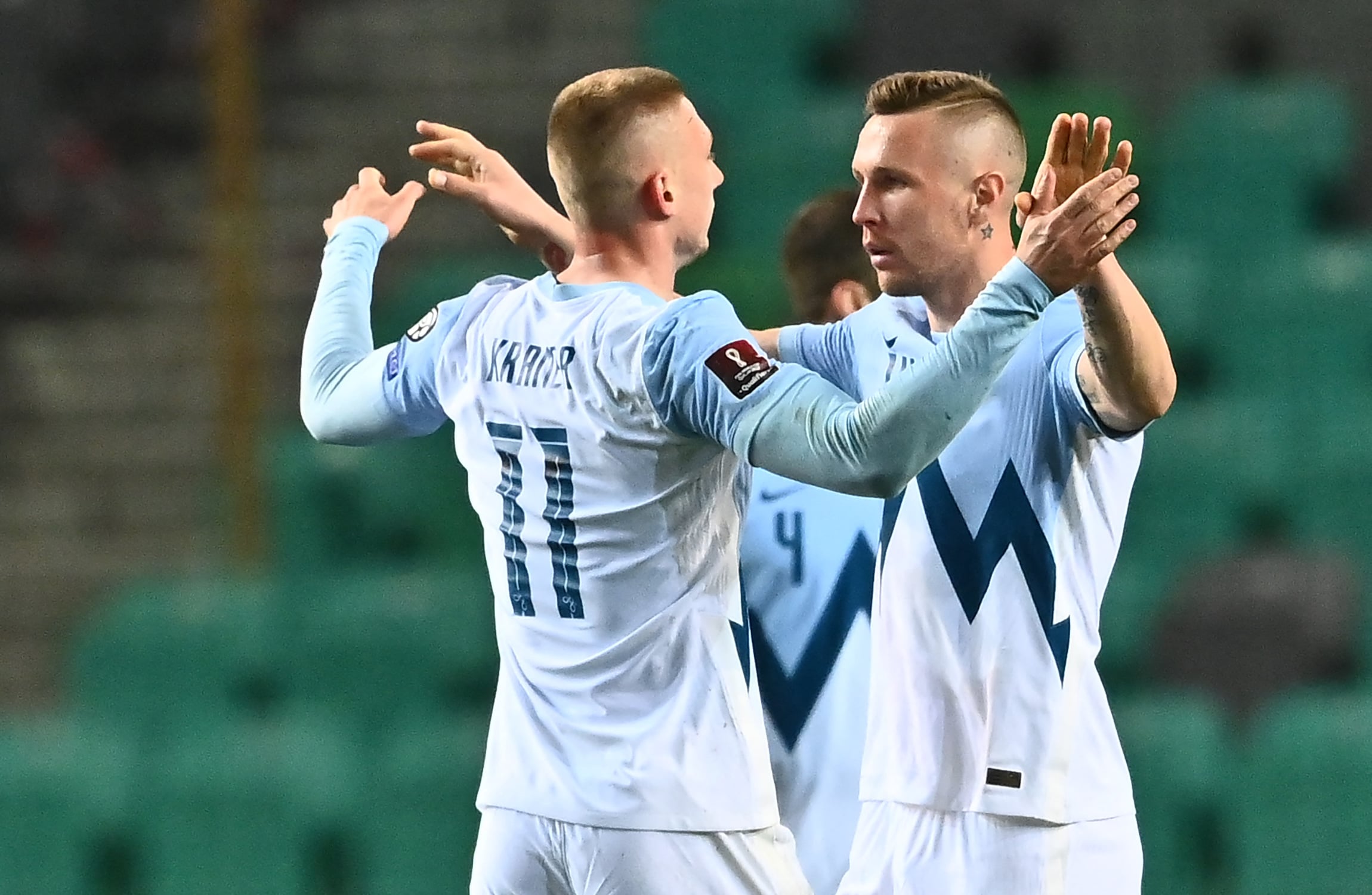 Dua pemain Slovenia merayakan kemenangan mereka atas Kroasia di laga kualifikasi Piala Dunia.