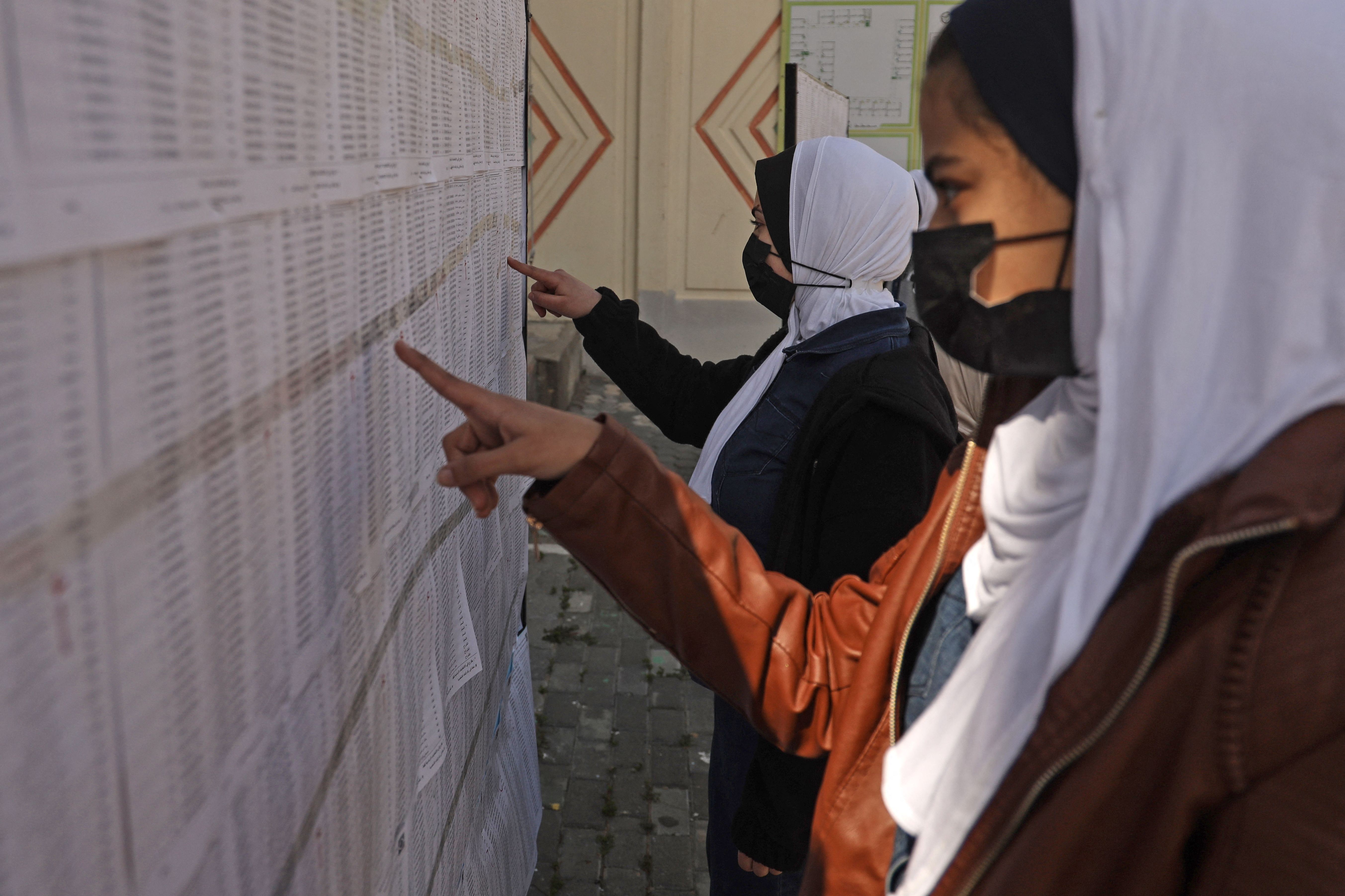 Wanita Palestina mencari nama mereka dalam daftar pemilih di suatu sekolah di Kota Gaza menjelang pemilu.