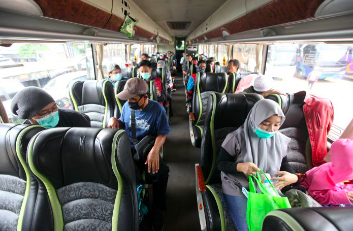 Calon penumpang menunggu bus keberangkatan ke beberapa daerah di Timur Jawa di terminal bayangan Lebak Bulus, Jakarta, Minggu (29/3).