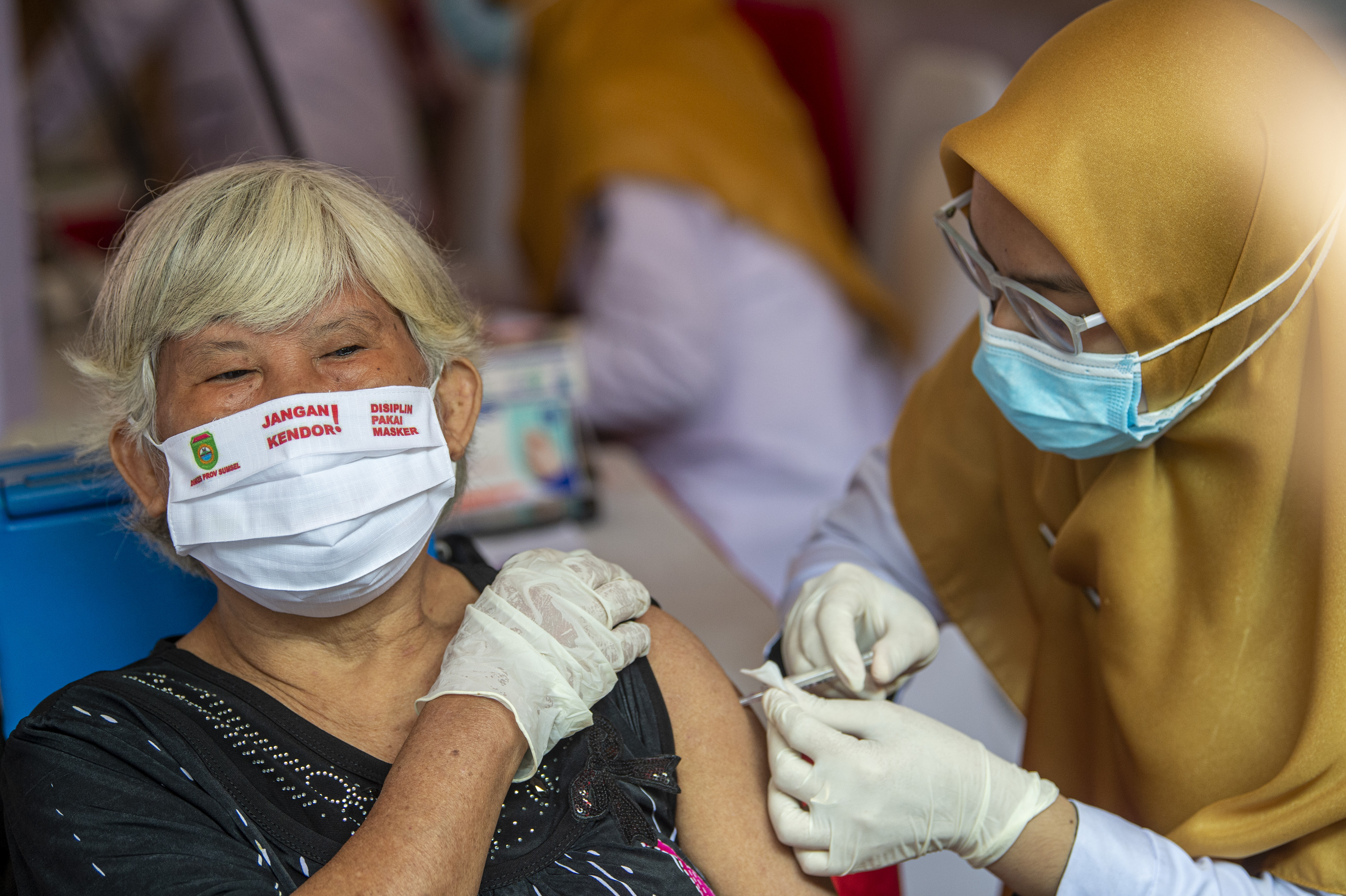 Petugas kesehatan menyuntikkan vaksin covid-19 kepada pedagang di Pasar Cinde, Palembang.