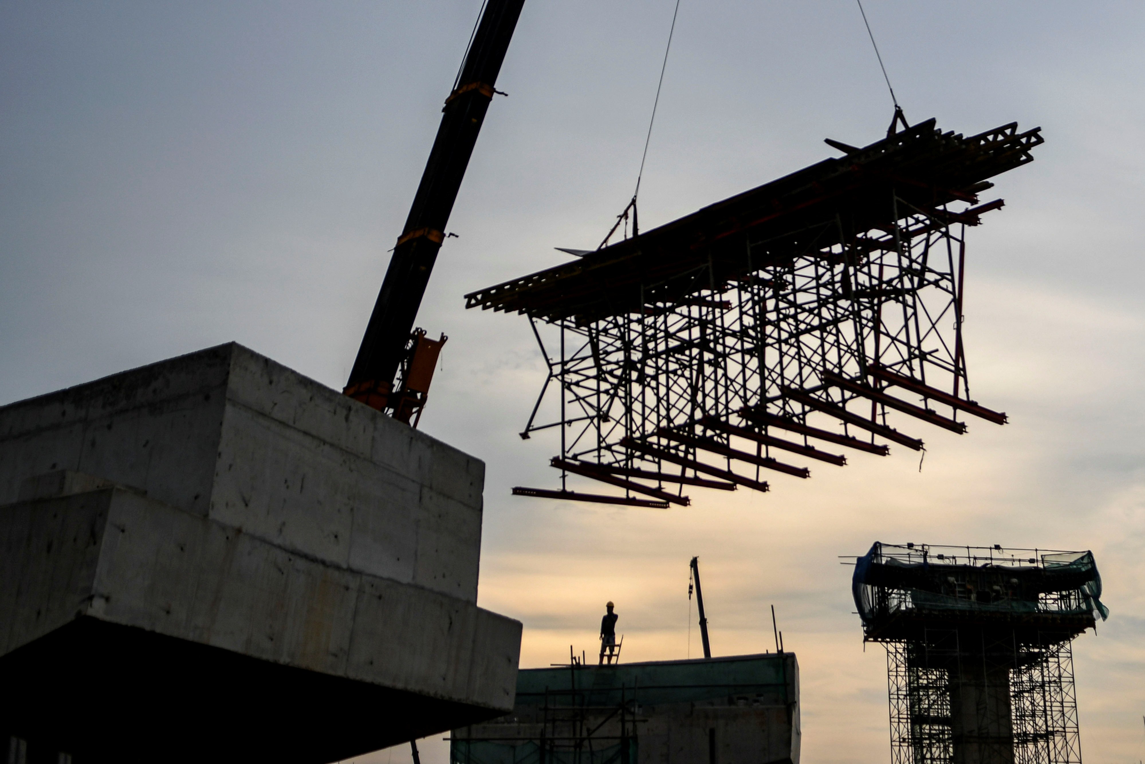 Pekerja menyelesaikan pembangunan ruas jalan tol dalam kota pada Seksi A Kelapa Gading-Pulogebang di kawasan Cakung, Jaktim, Kamis (4/3).